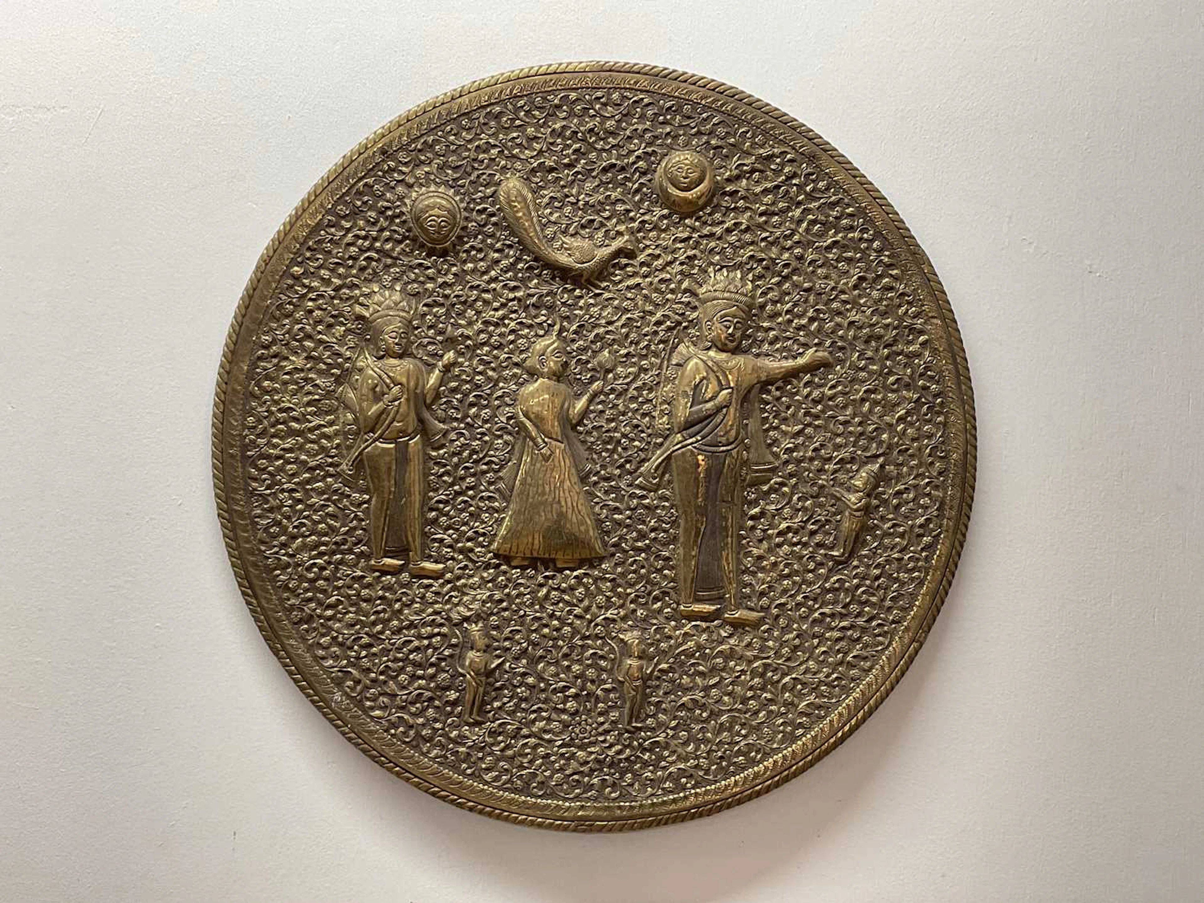 An Indian brass wall charger depicting figures and...
