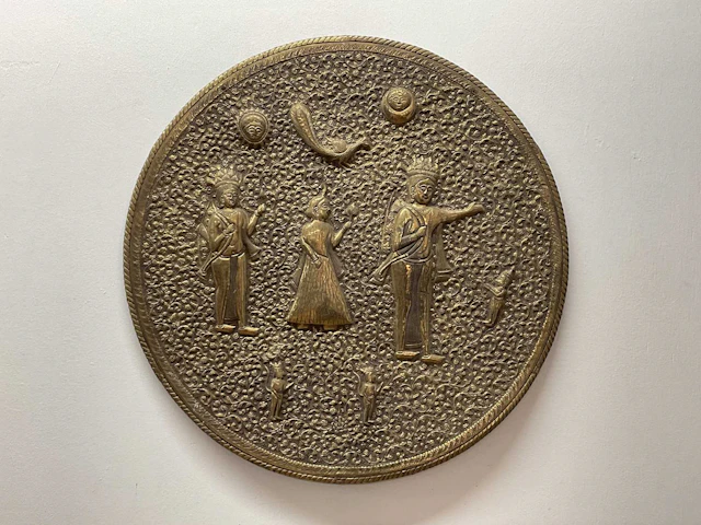 An Indian brass wall charger depicting figures and...