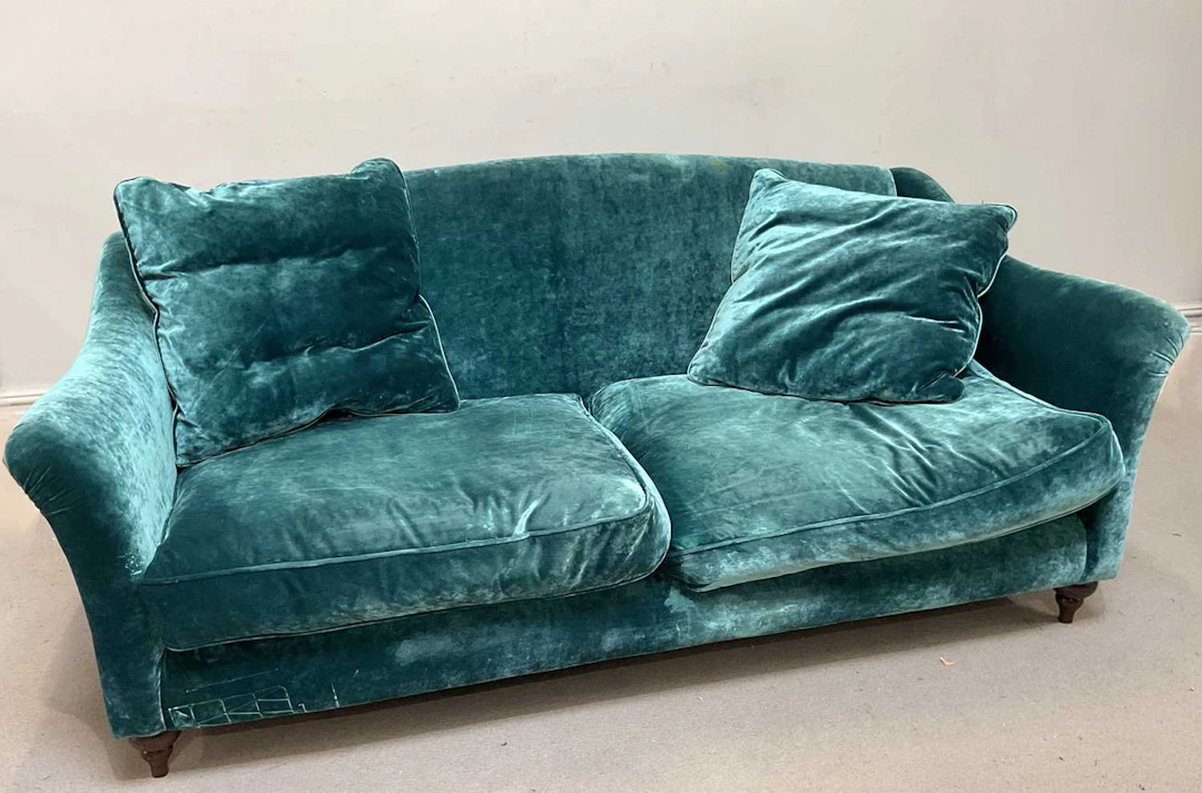 A contemporary two seater sofa with blue upholstery and label for Spink & Edgar