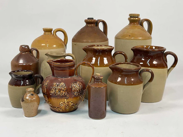 A quantity of stoneware and salt glazed flagons