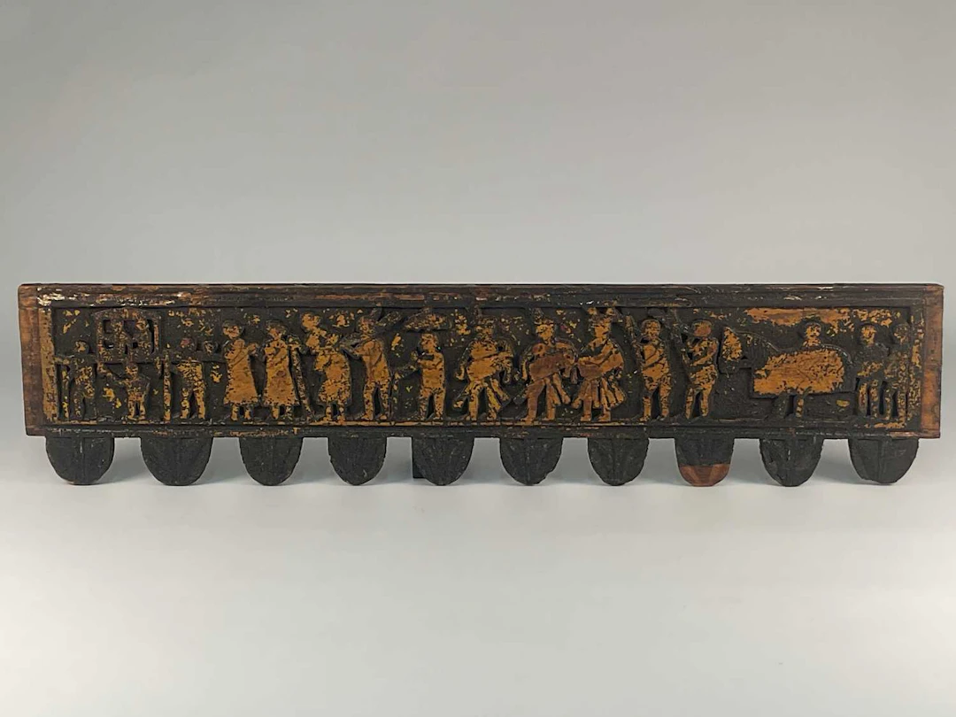 A Chinese carved wooden frieze depicting a procession of figures