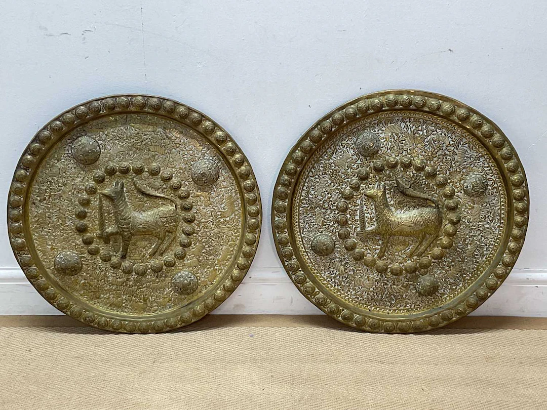 A pair of Middle Eastern brass wall chargers depicting a...