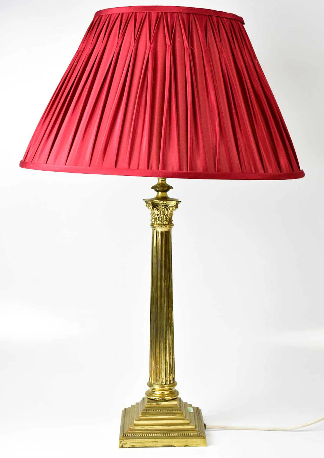 A brass table lamp in the form of a Corinthian column on a stepped square base