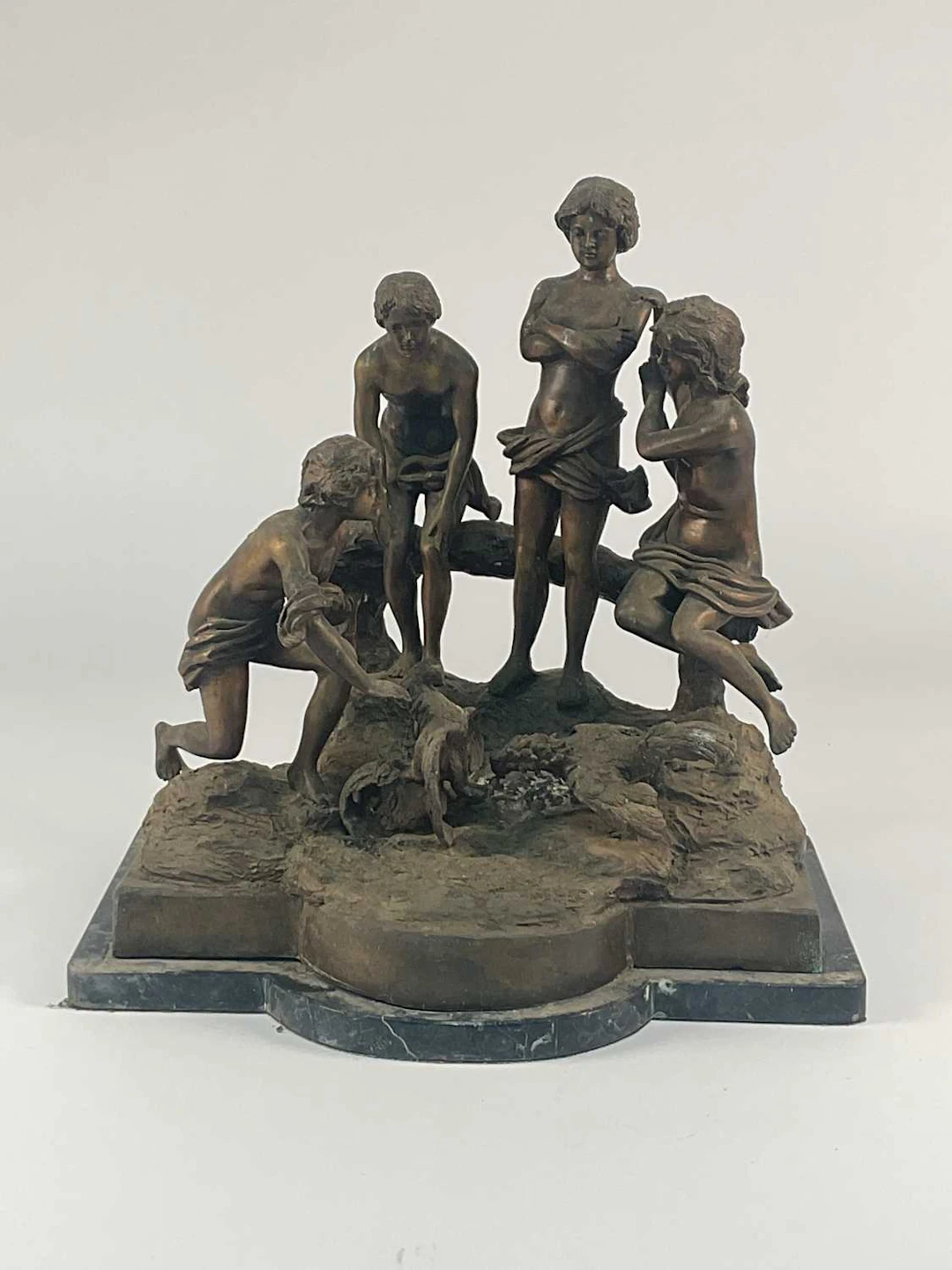 A bronzed patinated metal sculpture depicting a group of...