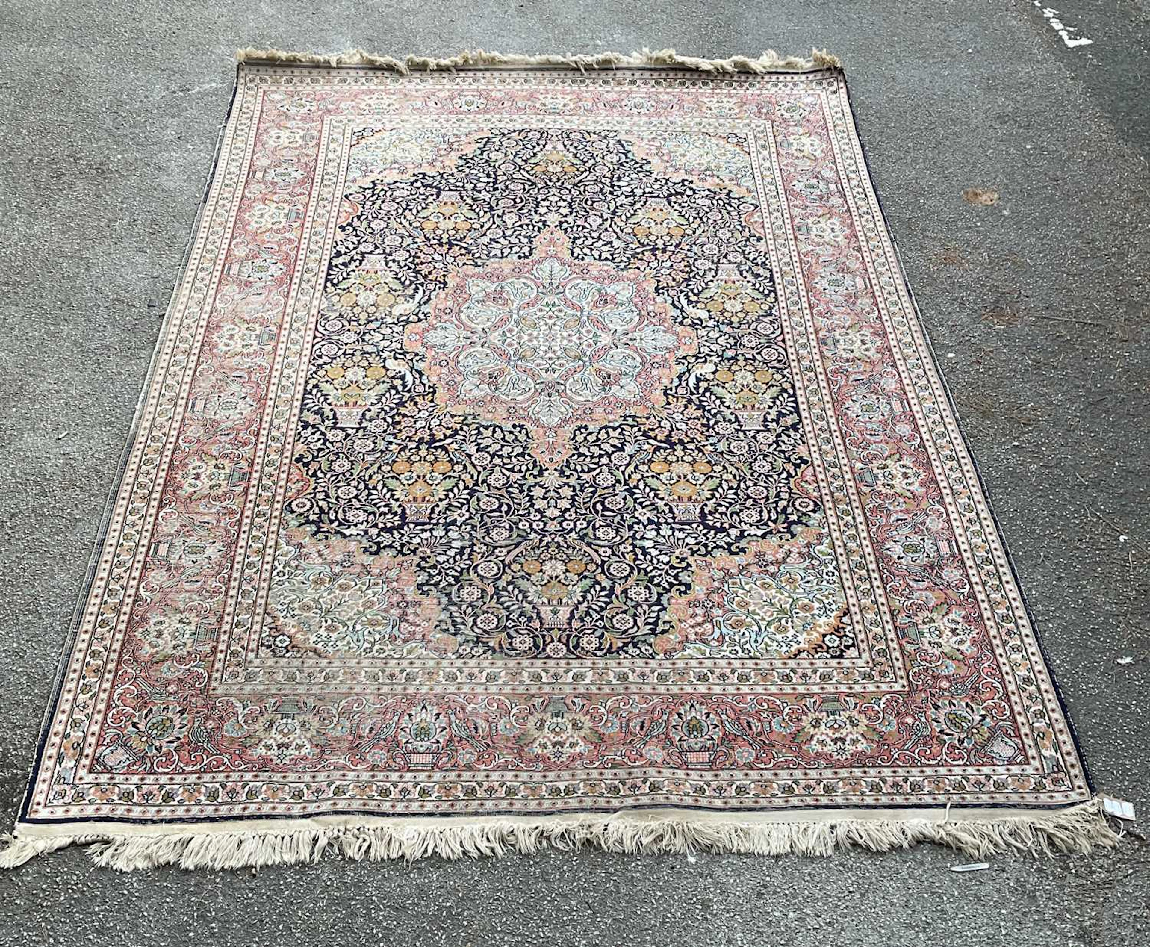 A blue ground hand knotted woollen carpet with central geometric pattern