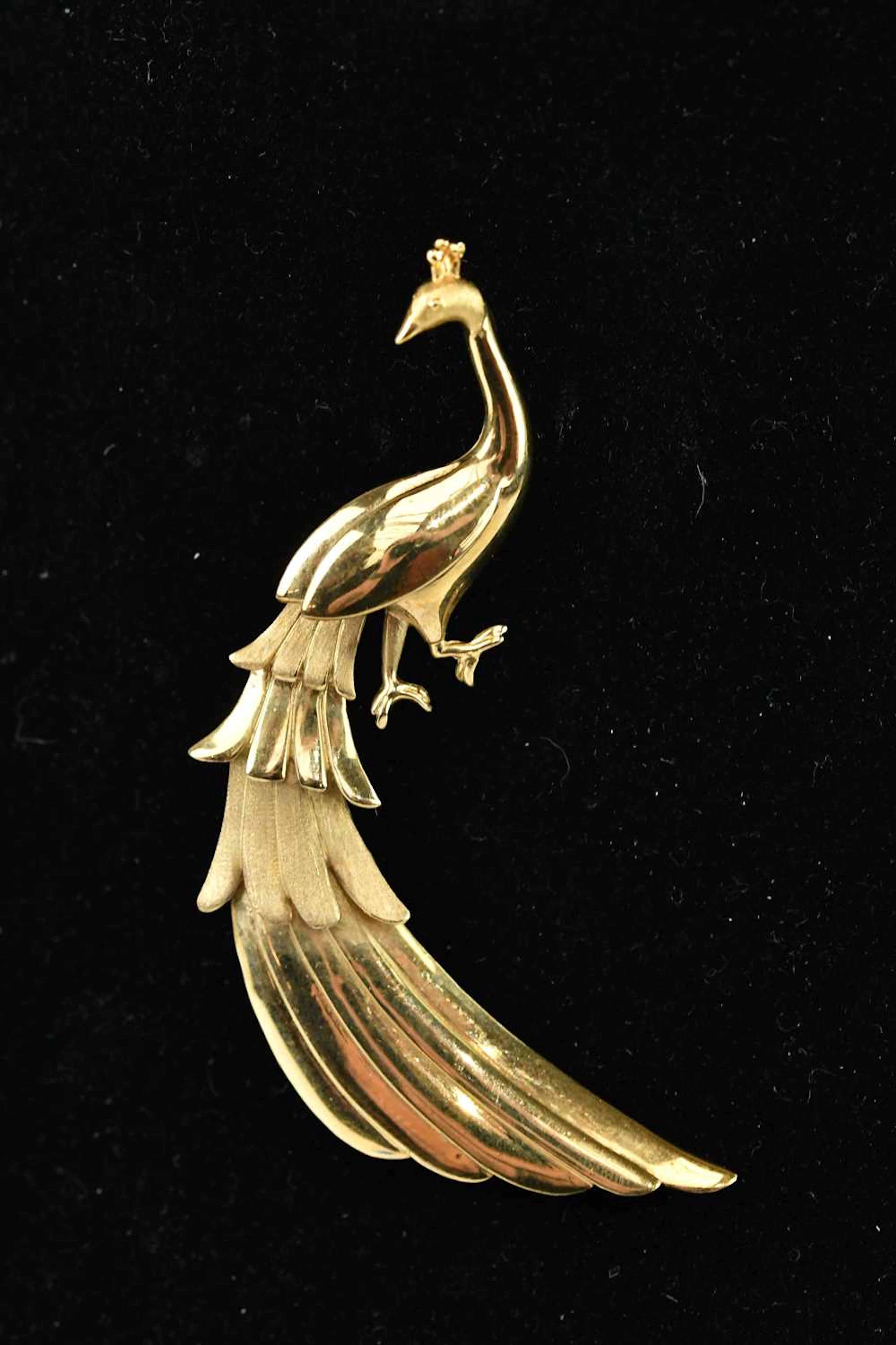 A yellow metal brooch modelled as a peacock
