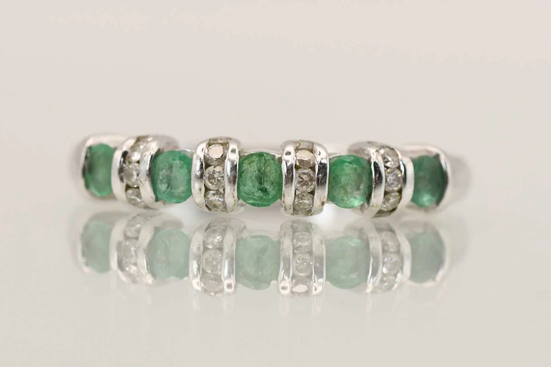 A 9ct white gold emerald and diamond set ring