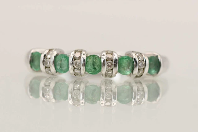 A 9ct white gold emerald and diamond set ring