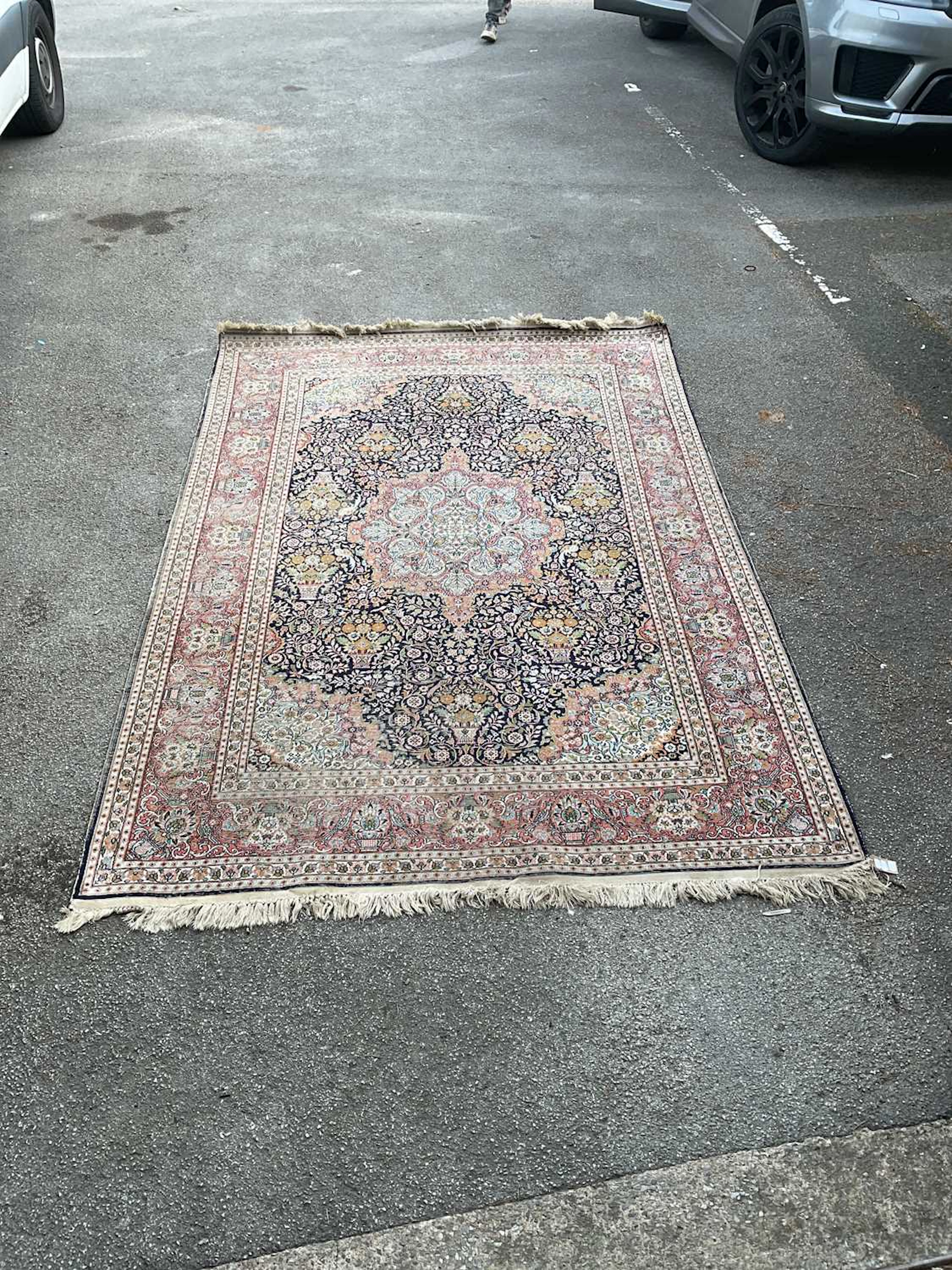 A blue ground hand knotted woollen carpet with central geometric pattern