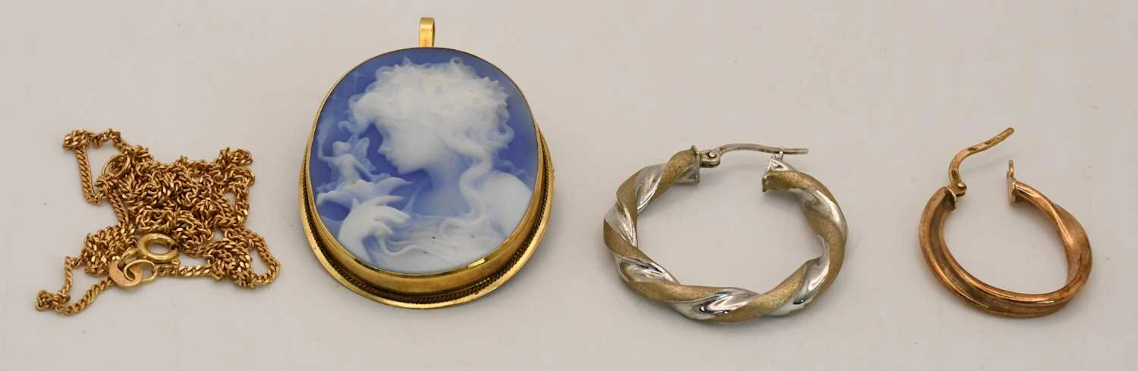 A cameo of a girl in yellow gold coloured pendant mount