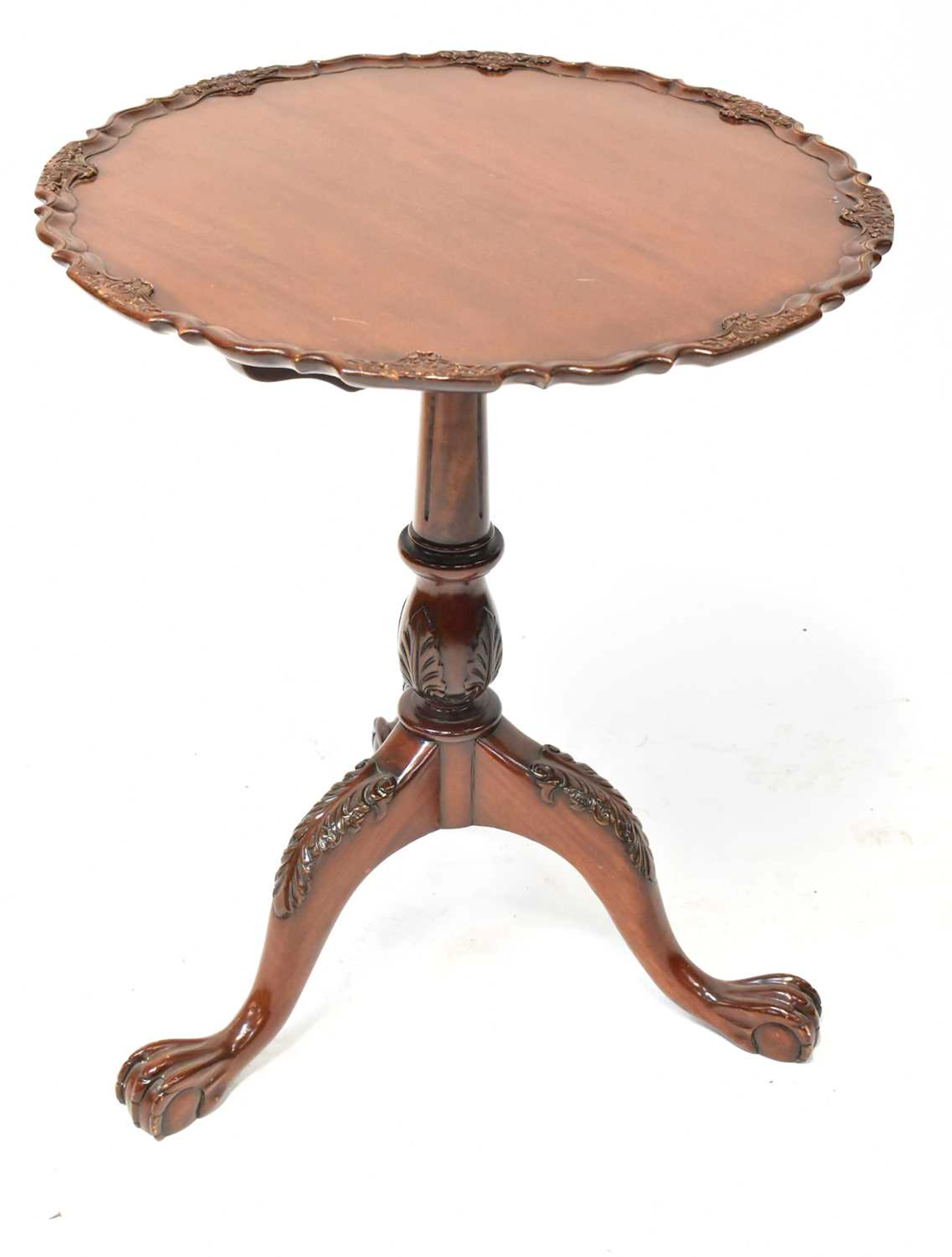 A reproduction occasional table with carved pie crust top