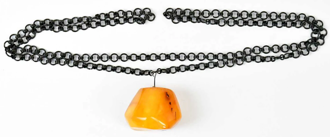 A c.1960s amber pendant on a continuous black chain