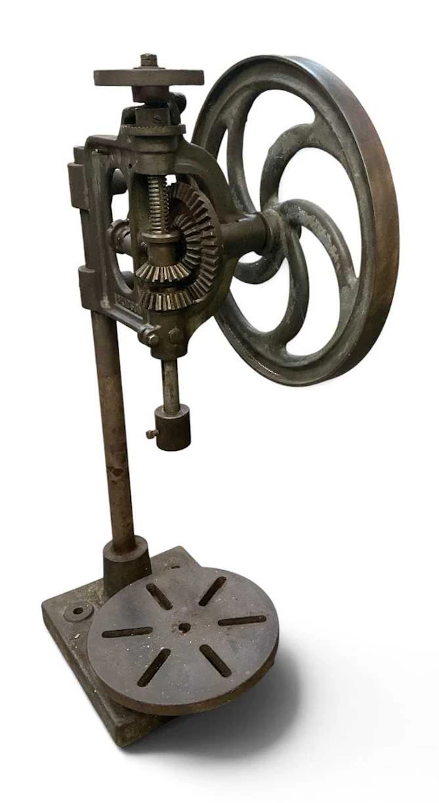 A vintage hand cranked cast iron pillar drill
