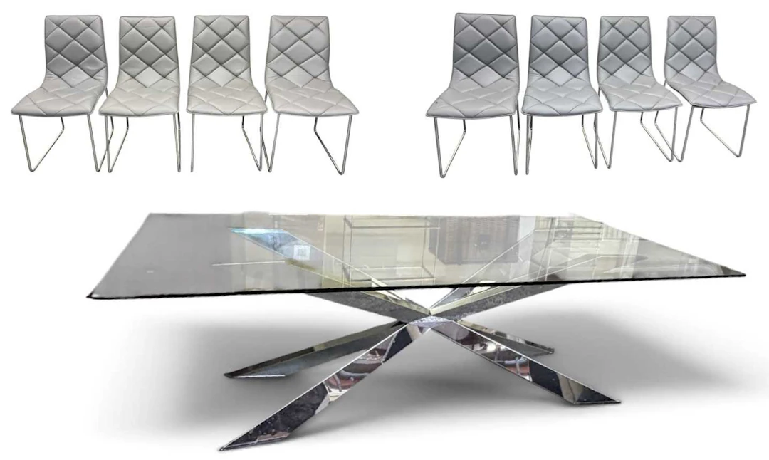 A large contemporary chrome X-framed dining table with glass top