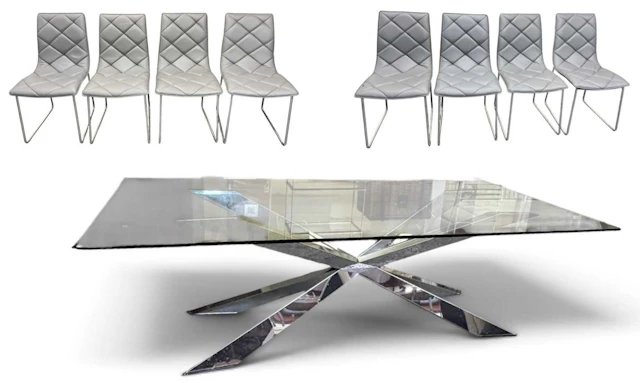 A large contemporary chrome X-framed dining table with glass top