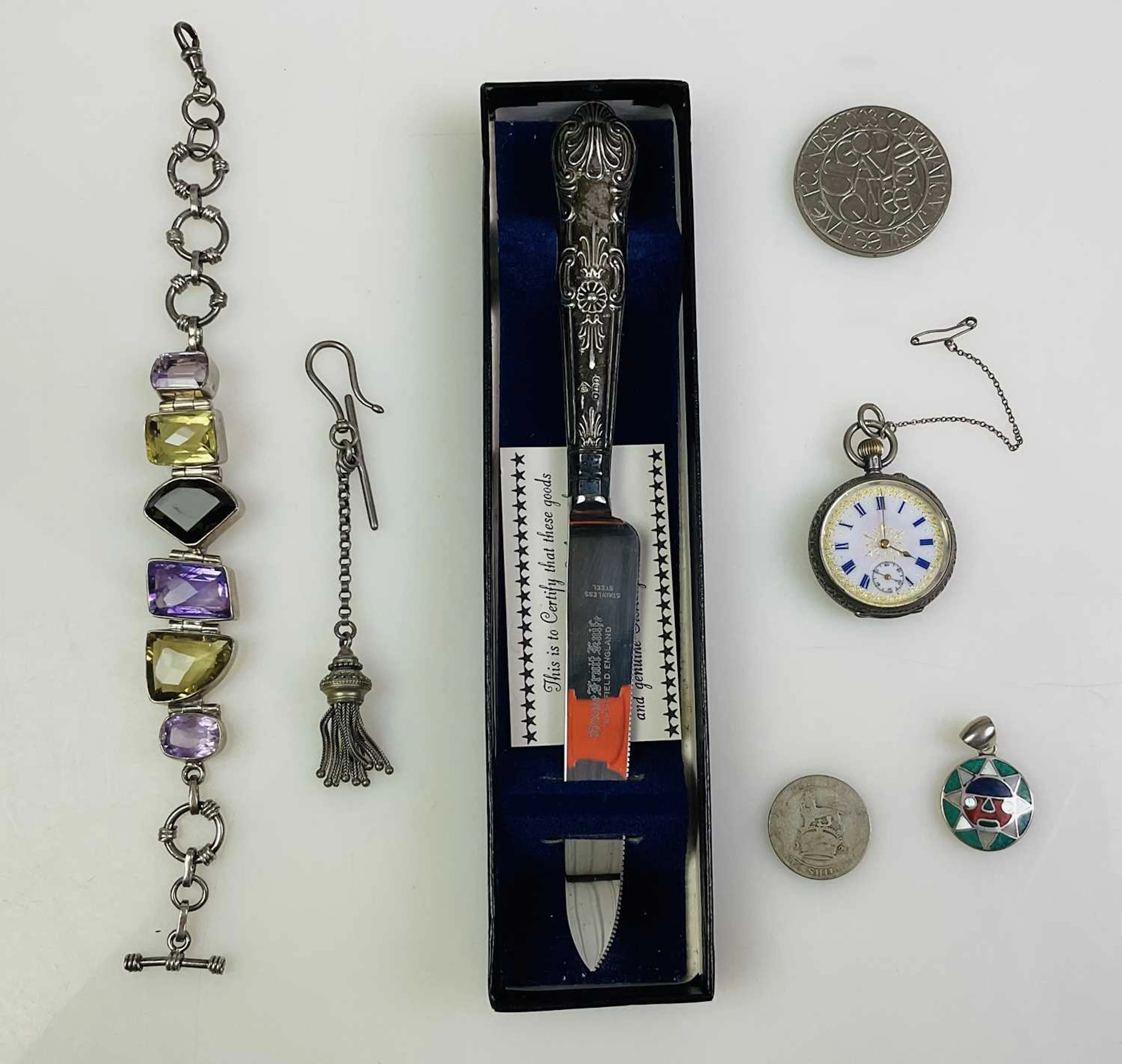 A white metal silver fob watch with Roman numeral dial
