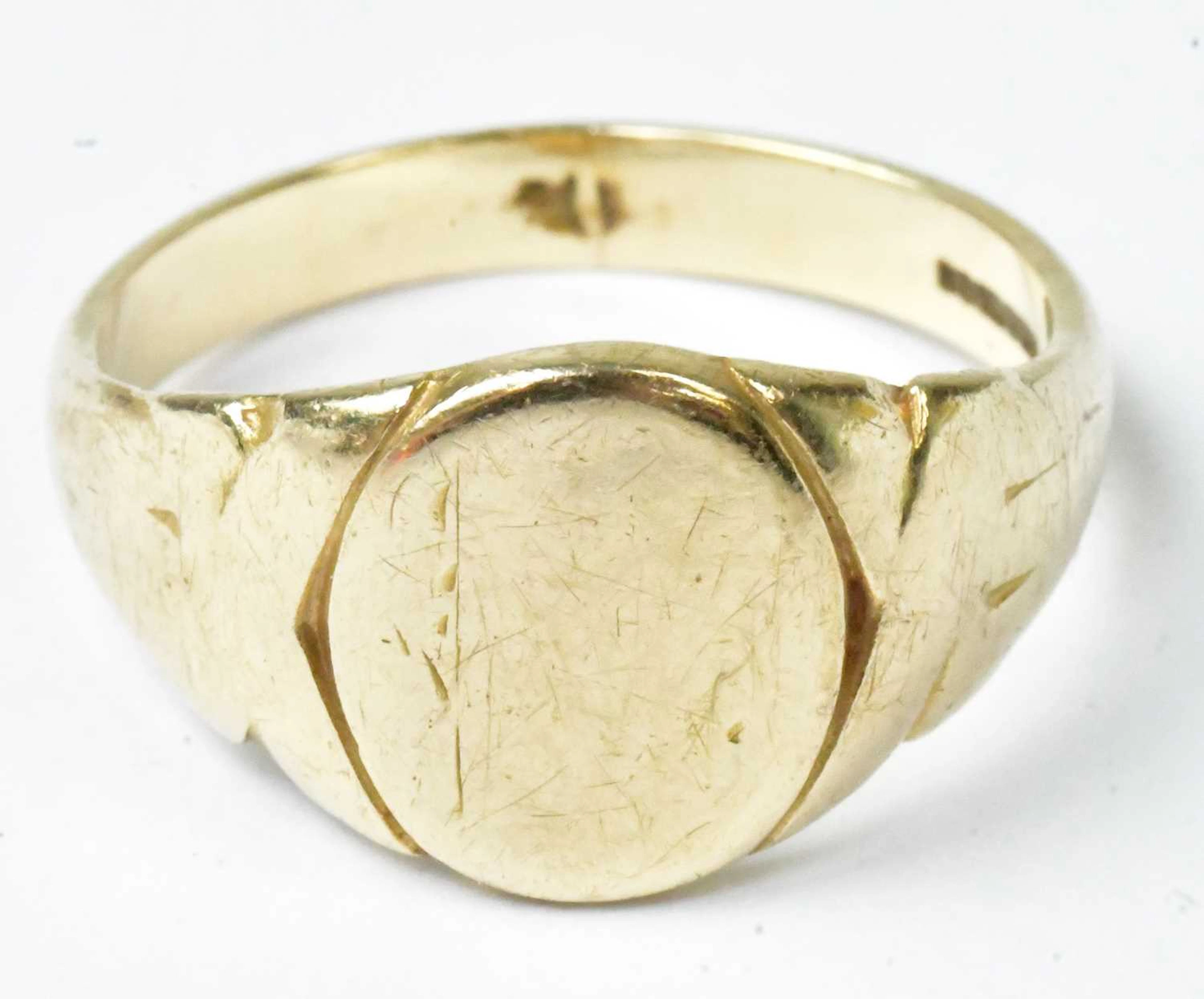 A 9ct yellow gold signet ring with engraved detail to the oval bezel (rubbed)