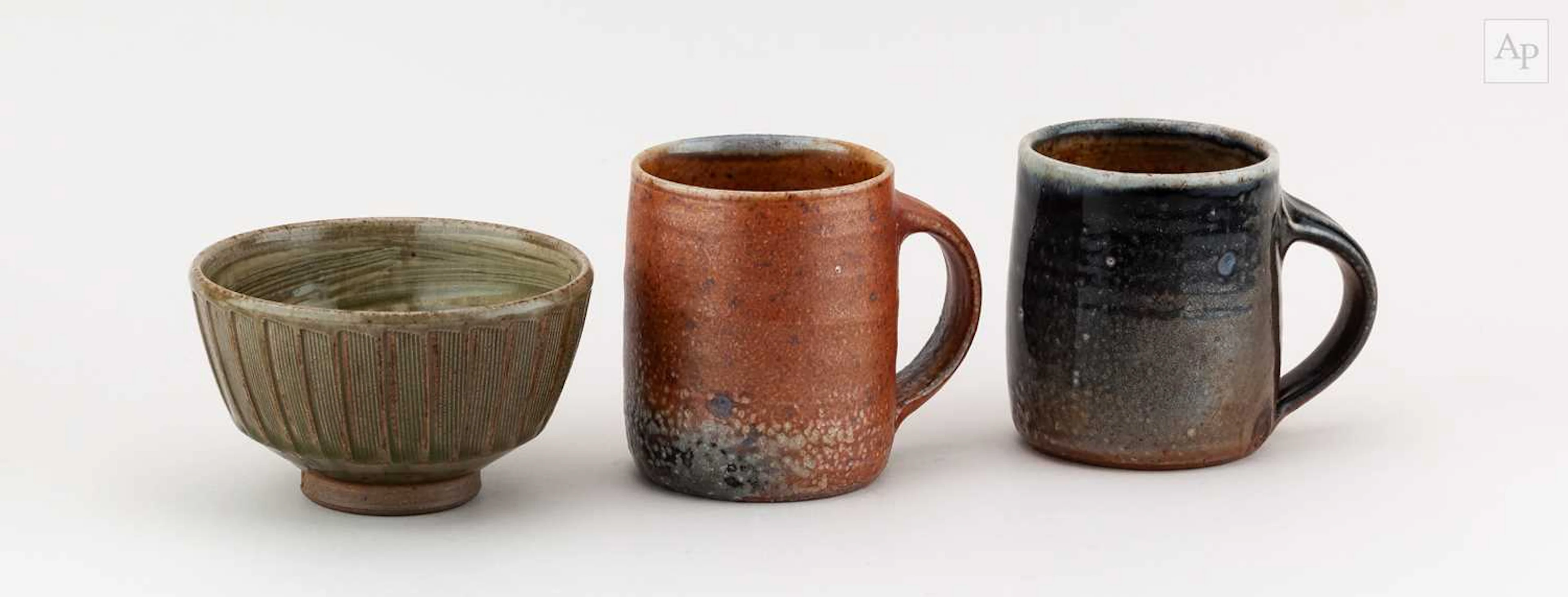 Maze Hill Pottery; a near pair of stoneware mugs covered in soda shino glaze