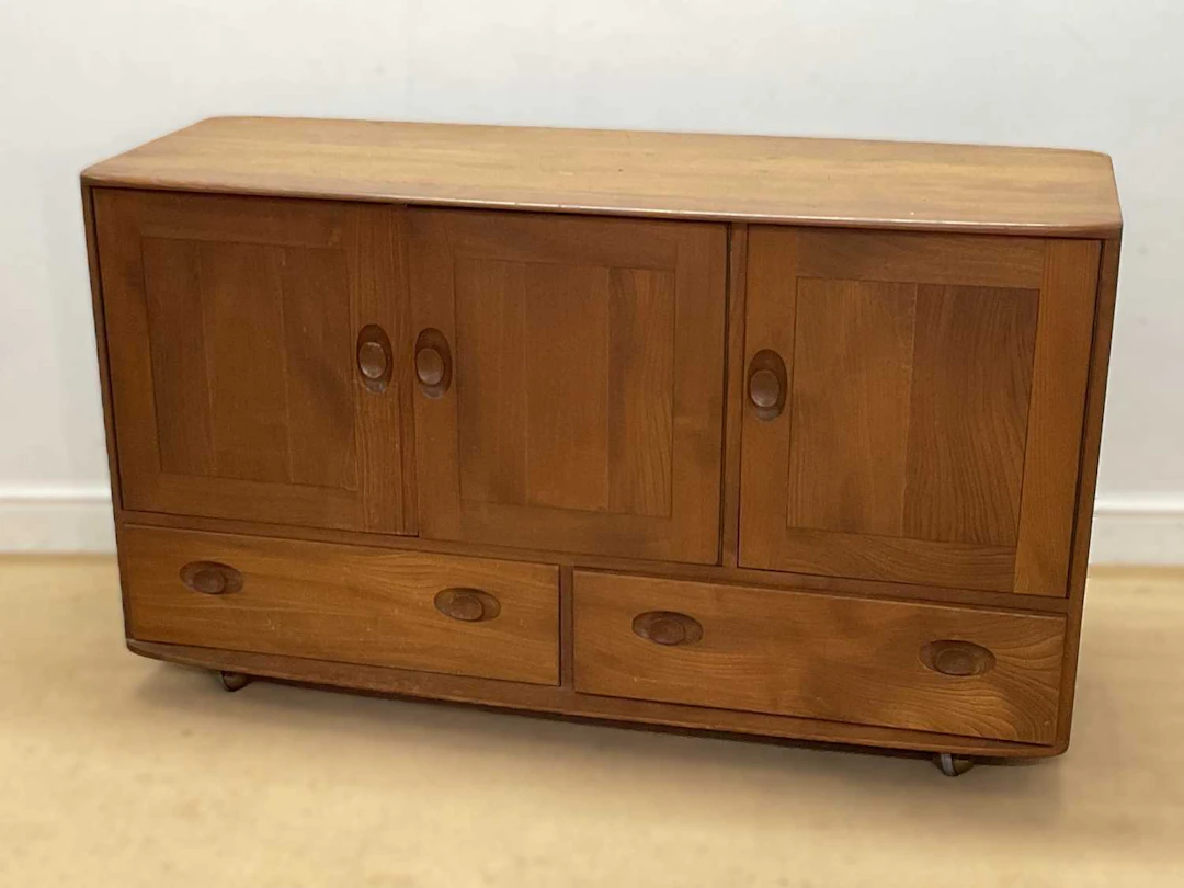 ERCOL; a 'Windsor' elm sideboard on castors