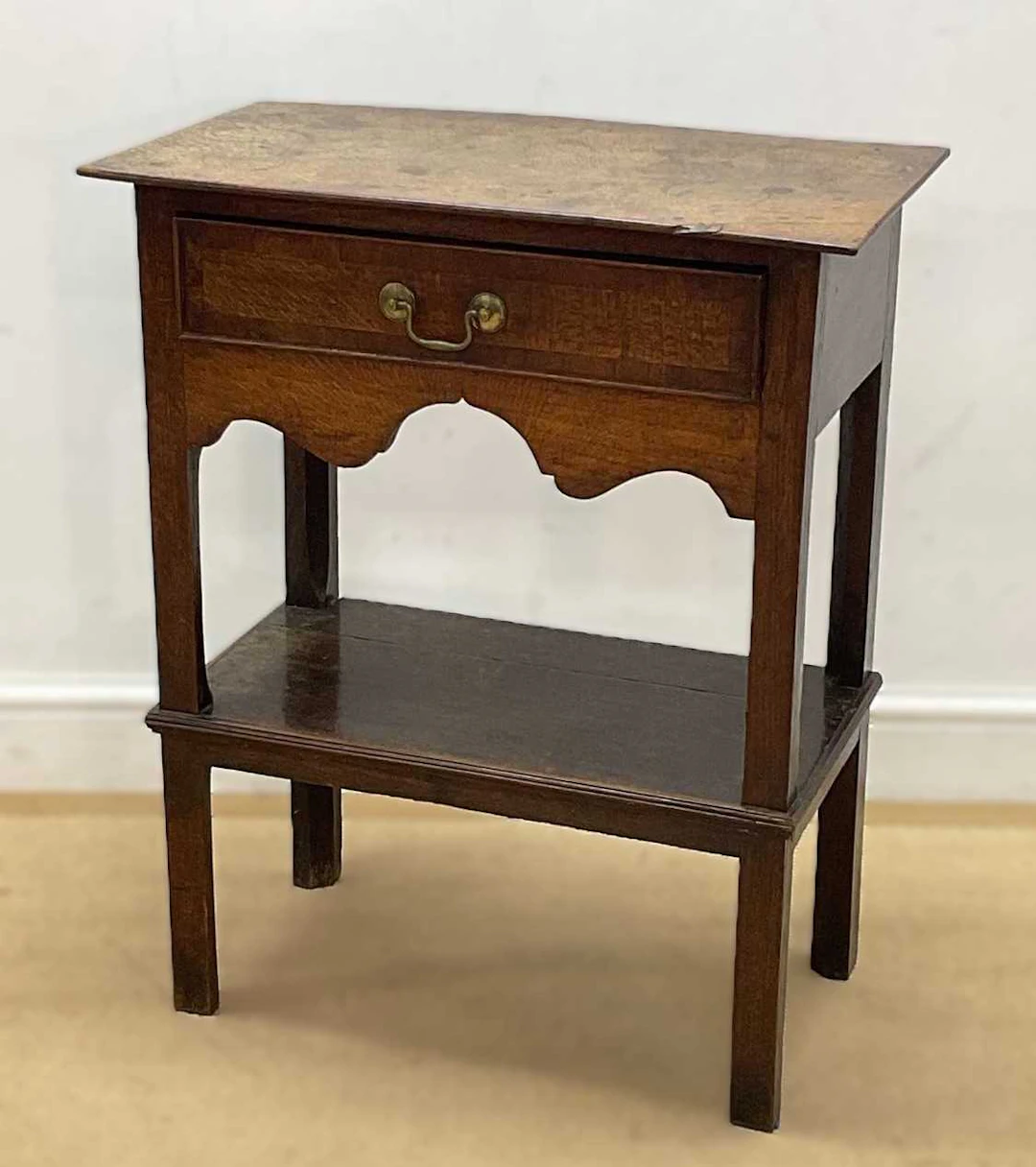 A Georgian oak table with single drawer and shelf beneath