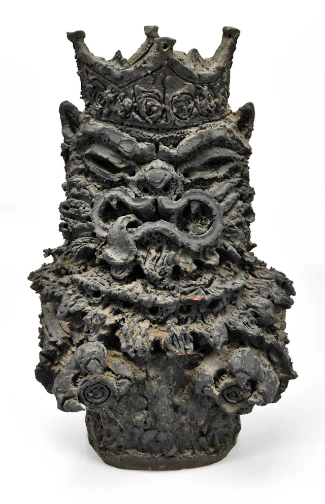 A possibly Japanese terracotta sculpture with grotesque face wearing a crown
