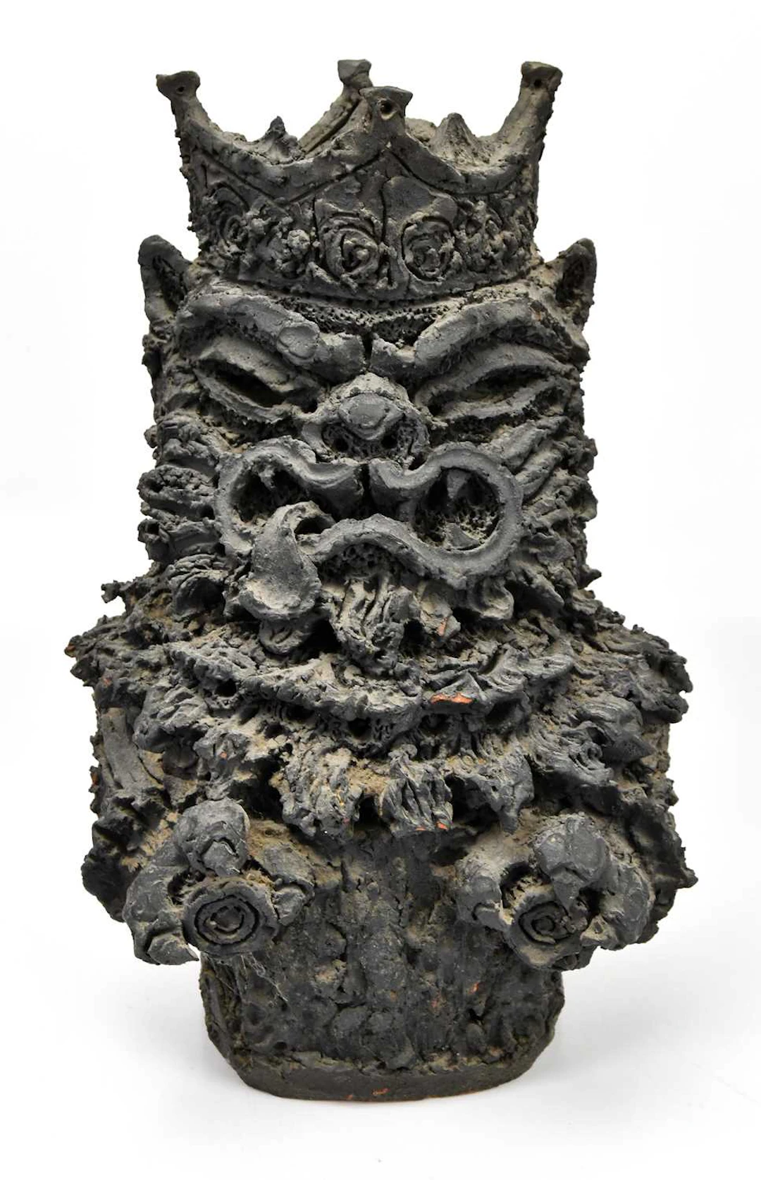 A possibly Japanese terracotta sculpture with grotesque face wearing a crown