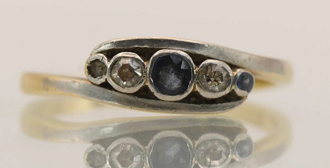 An 18ct yellow gold five stone sapphire and diamond set crossover dress ring