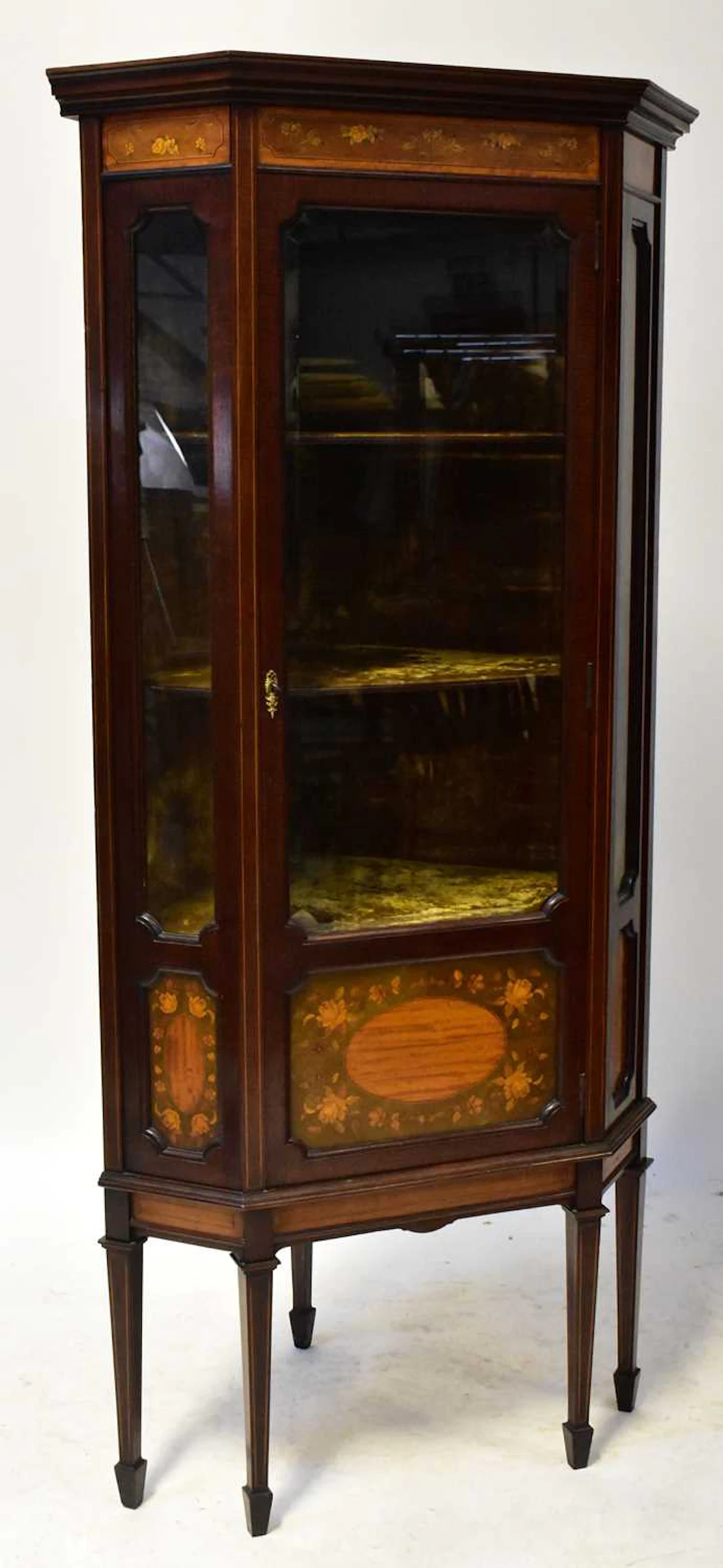 An Edwardian Sheraton style inlaid mahogany glazed floorstanding corner cabinet