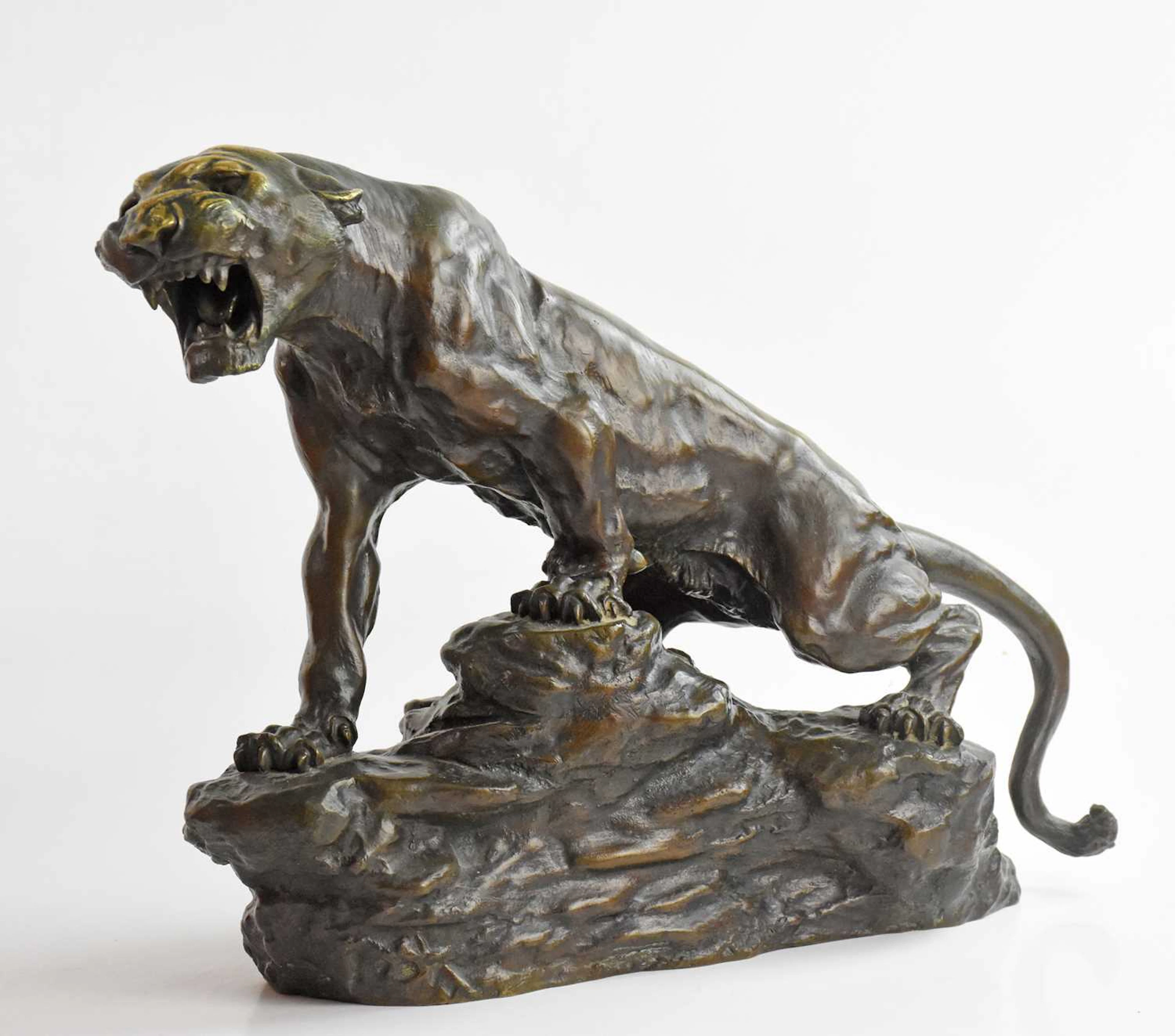 AFTER THOMAS FRANÇOIS CARTIER; a cast bronze model of a tiger climbing a rock