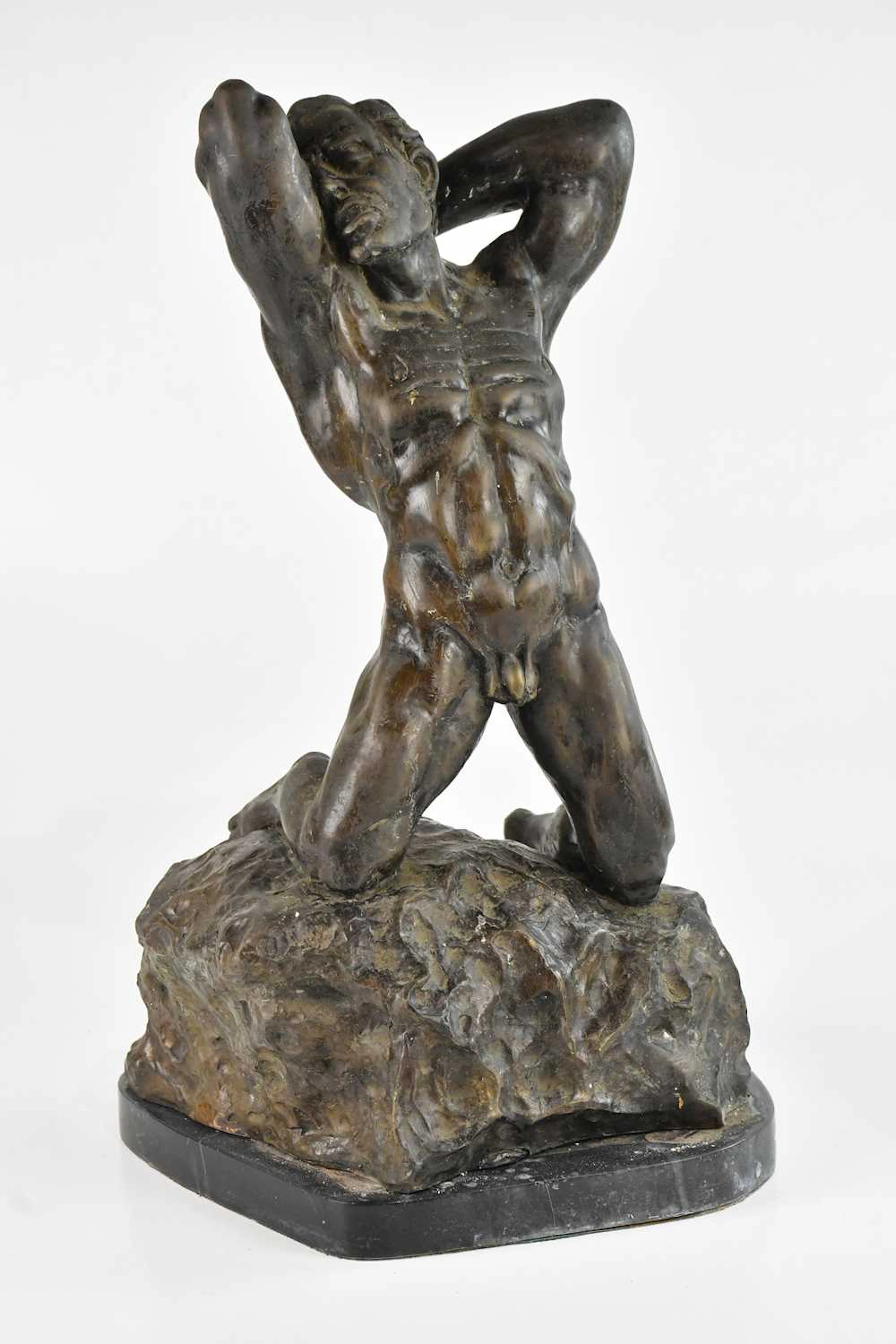AFTER ALFREDO PINA; a large modern bronze of a kneeling naked man on rock