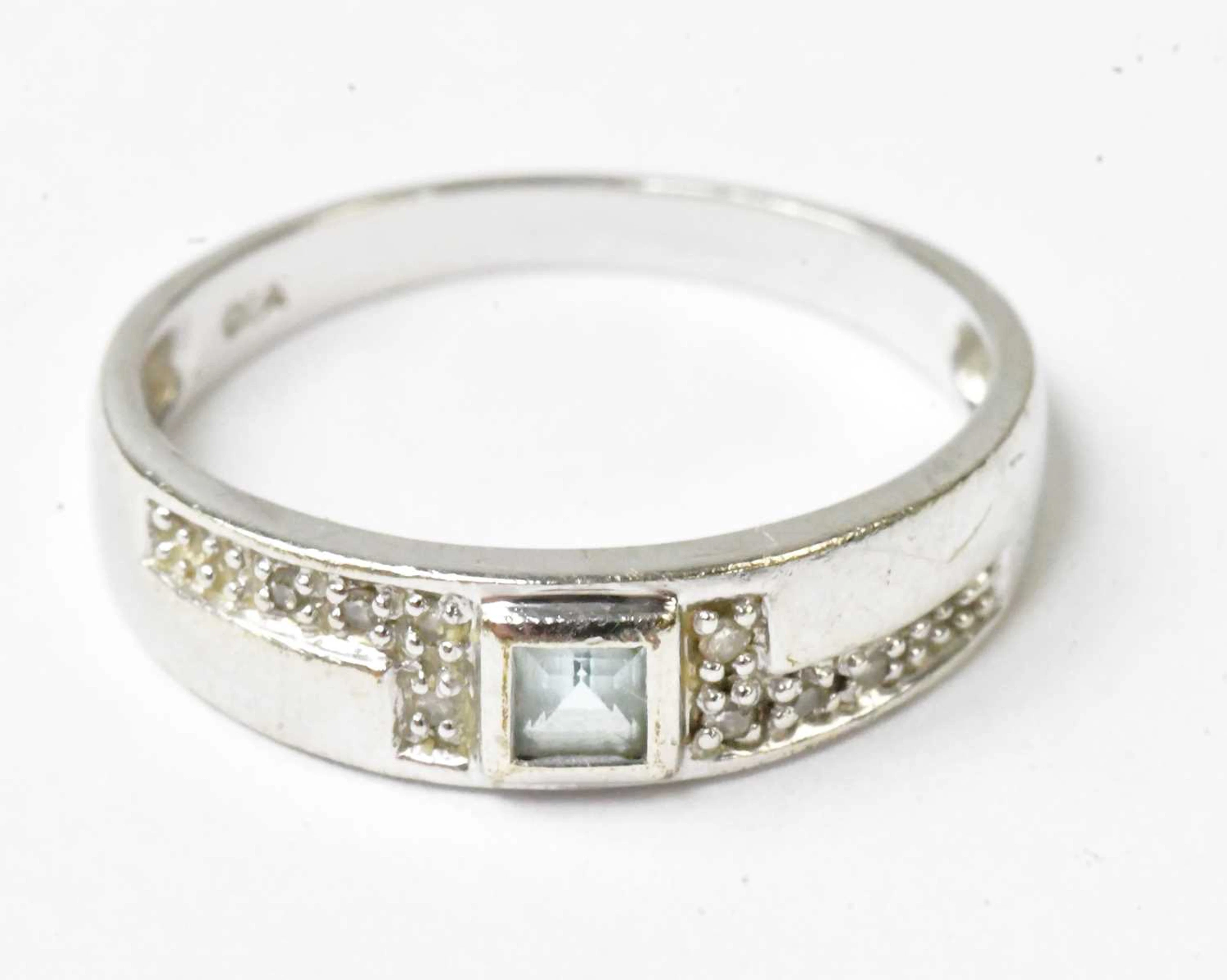 A 9ct white gold ring set with a central princess cut...