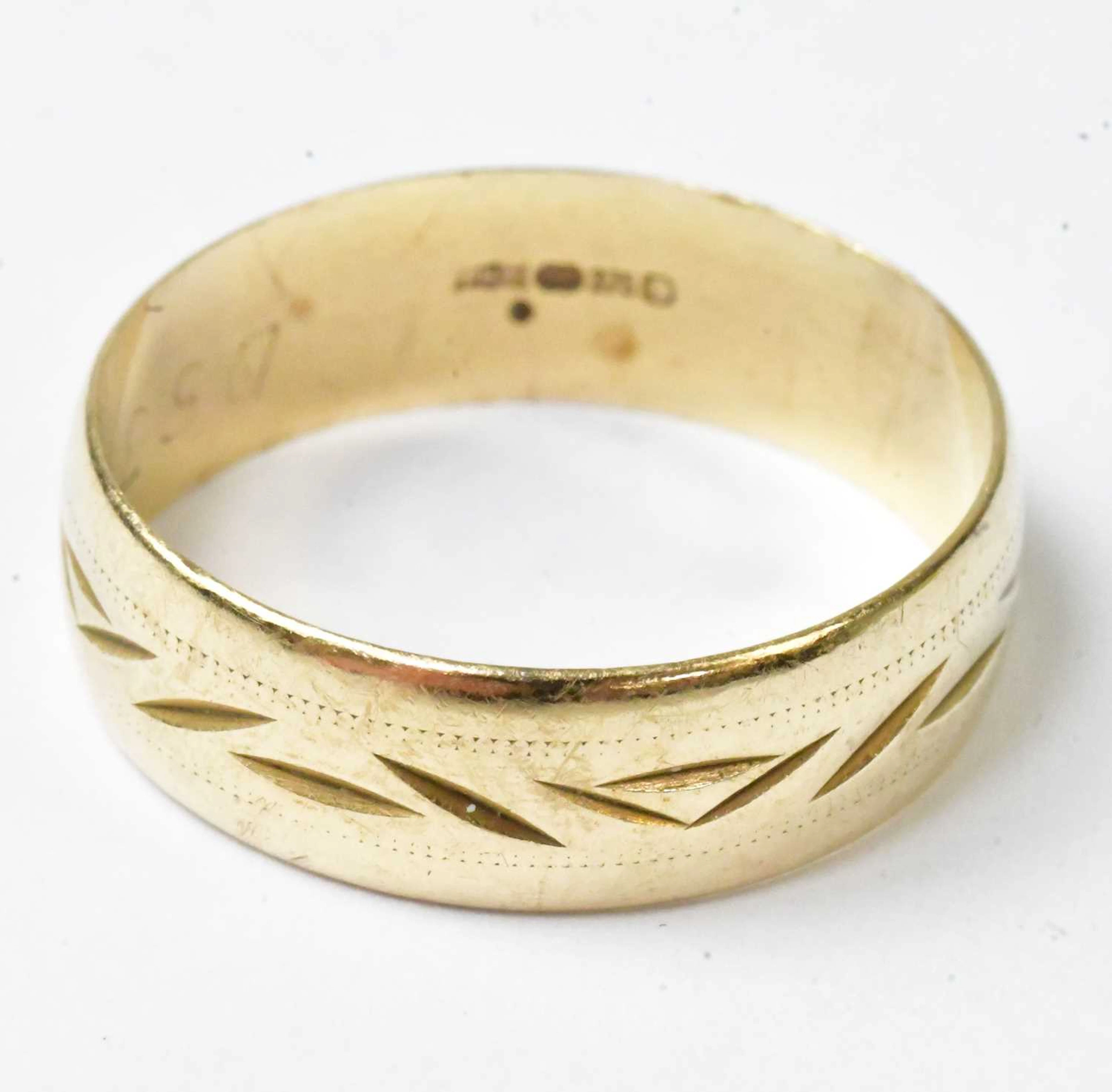 A 9ct yellow gold wedding band with engraved decoration