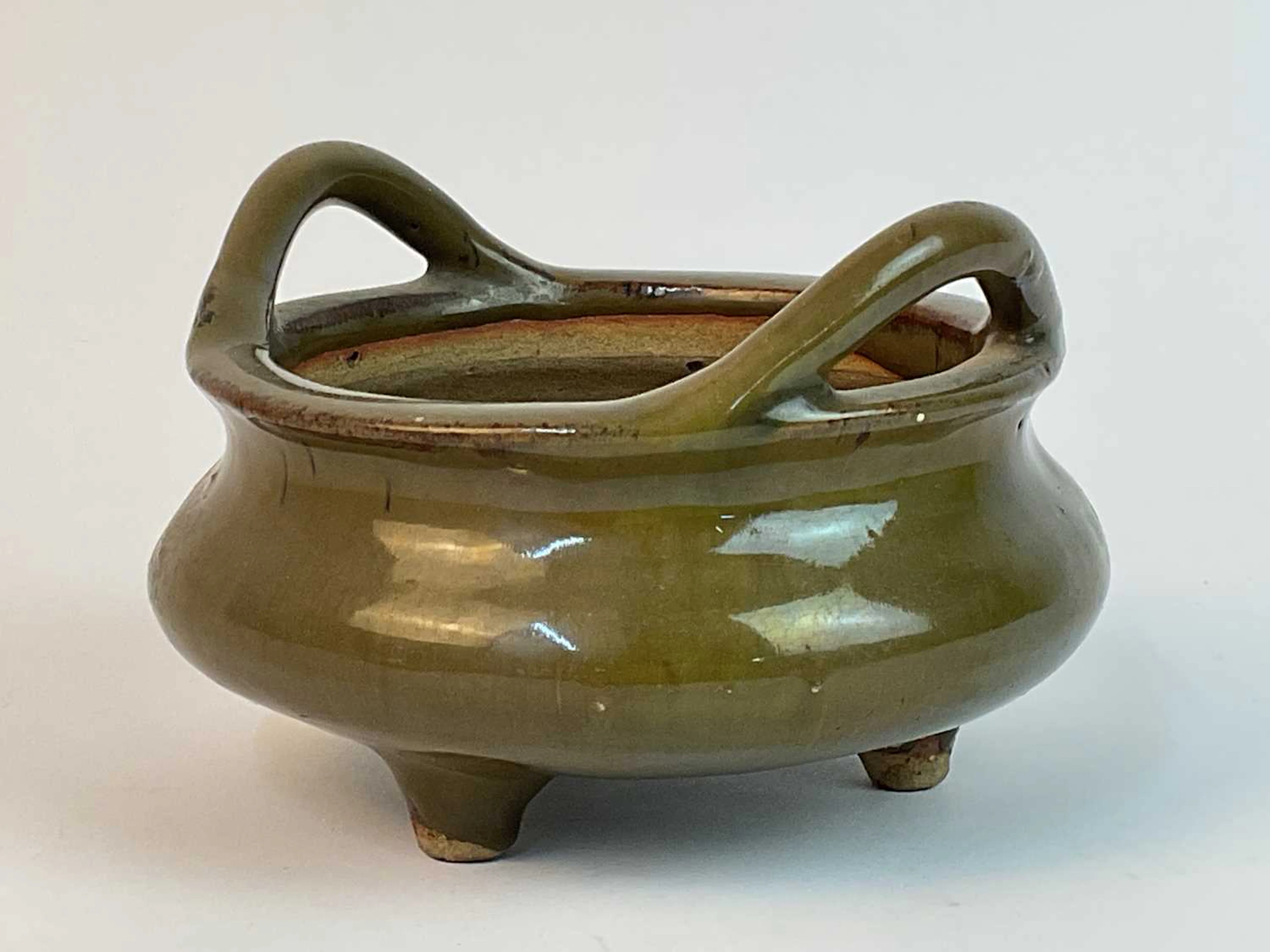 A Chinese green glazed ceramic censer on tripod supports