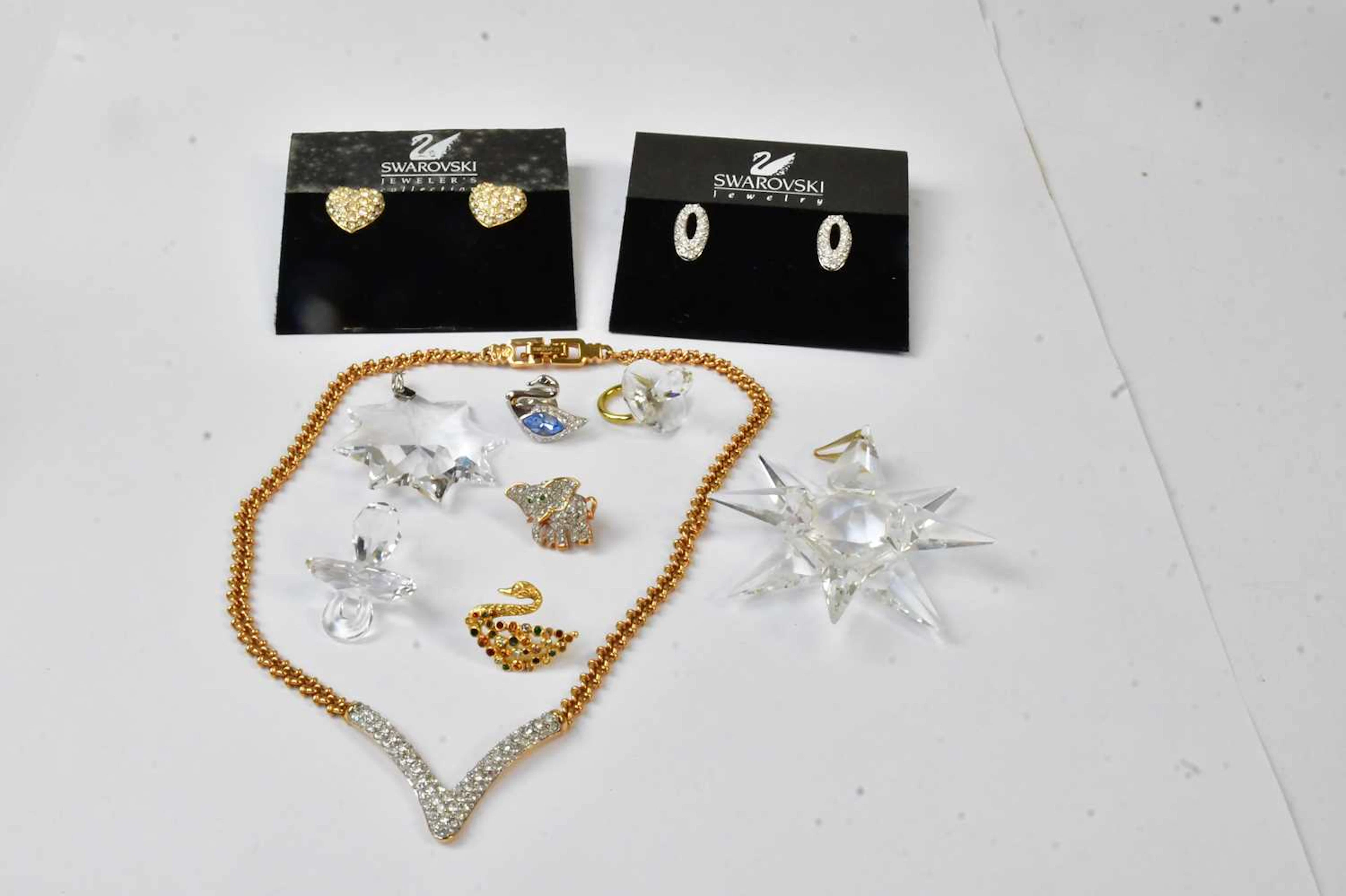 SWAROVSKI; a wishbone-shaped pendant on a gold-coloured chain