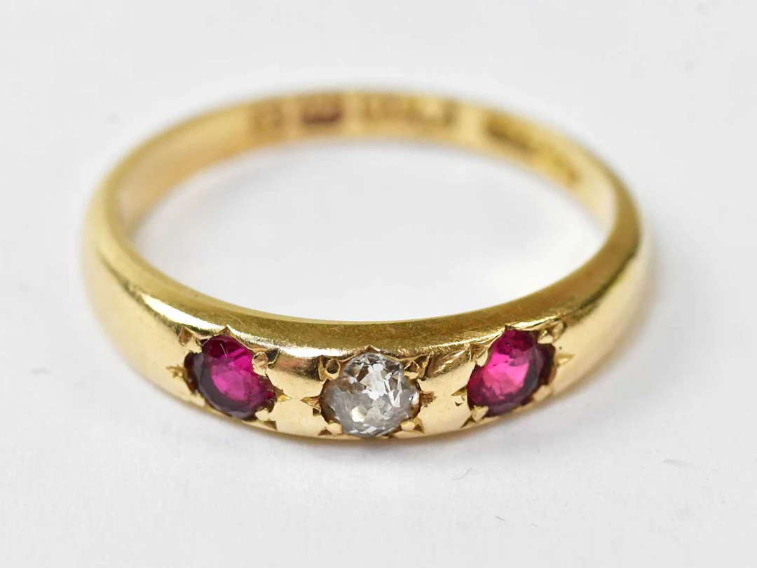 An 18ct yellow gold ring set with a central diamond and two rubies