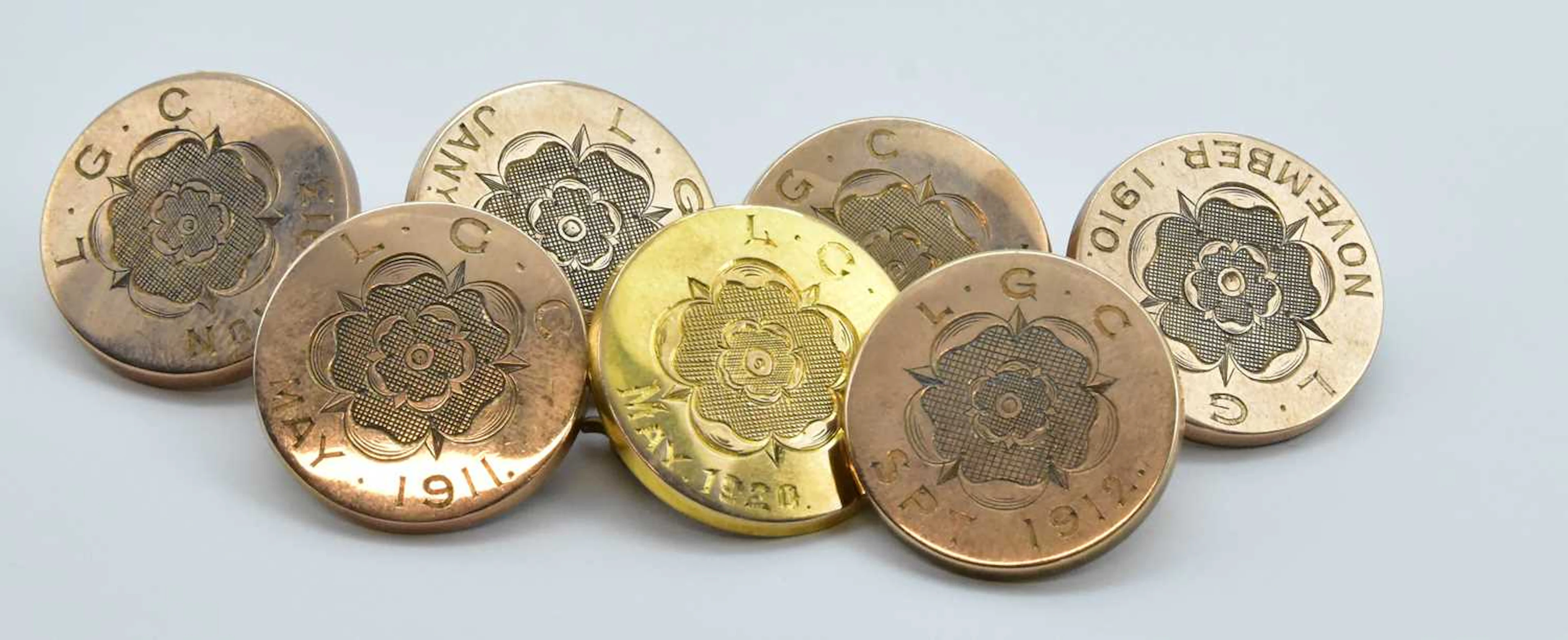 A group of seven rose gold fronted buttons with gilt metal backs