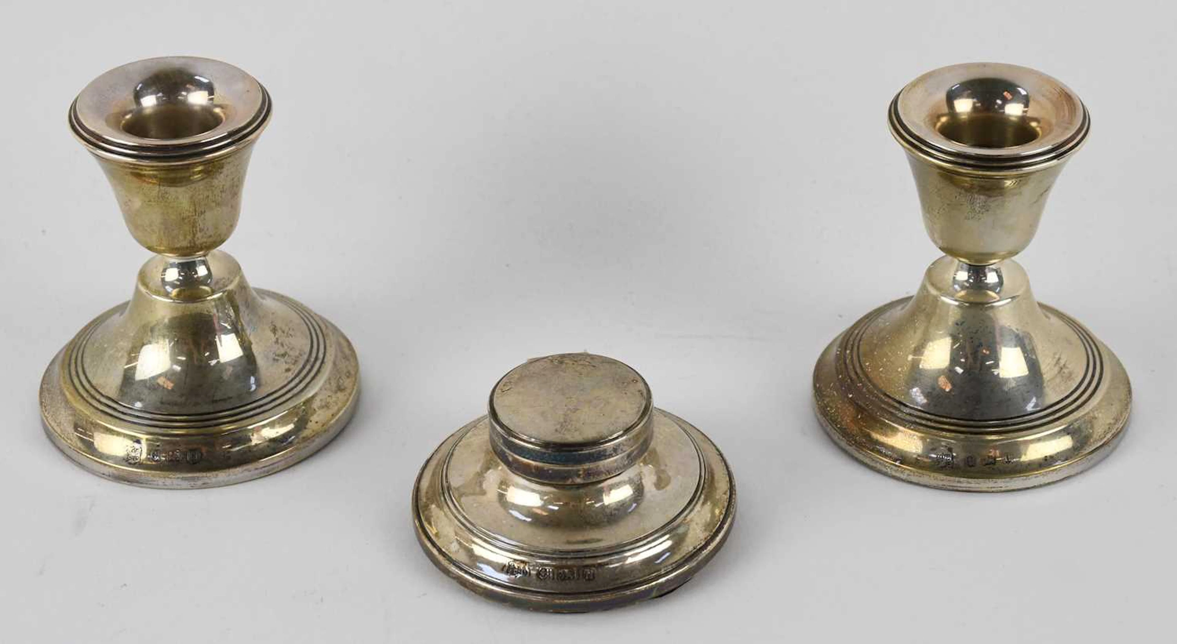 A cased pair of George V hallmarked silver squat candlesticks