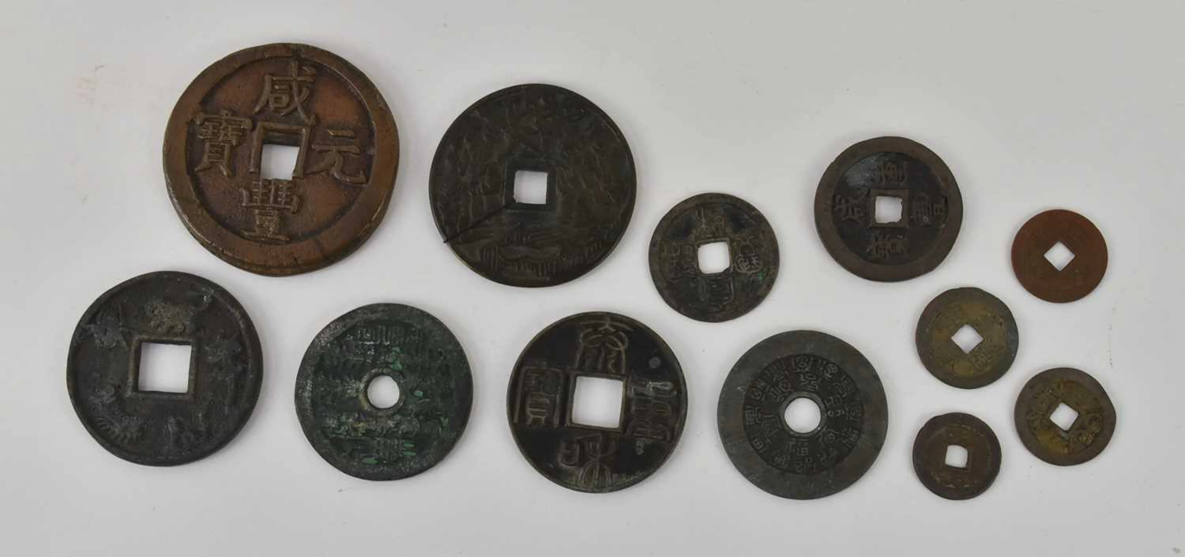 Twelve assorted Chinese and Japanese tokens