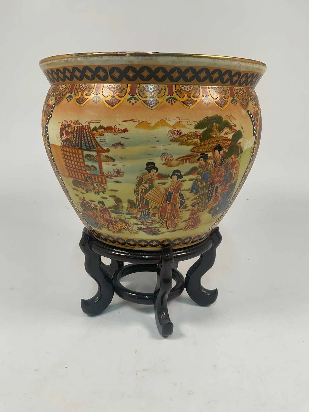 A Japanese fish bowl decorated with figures in a landscape setting