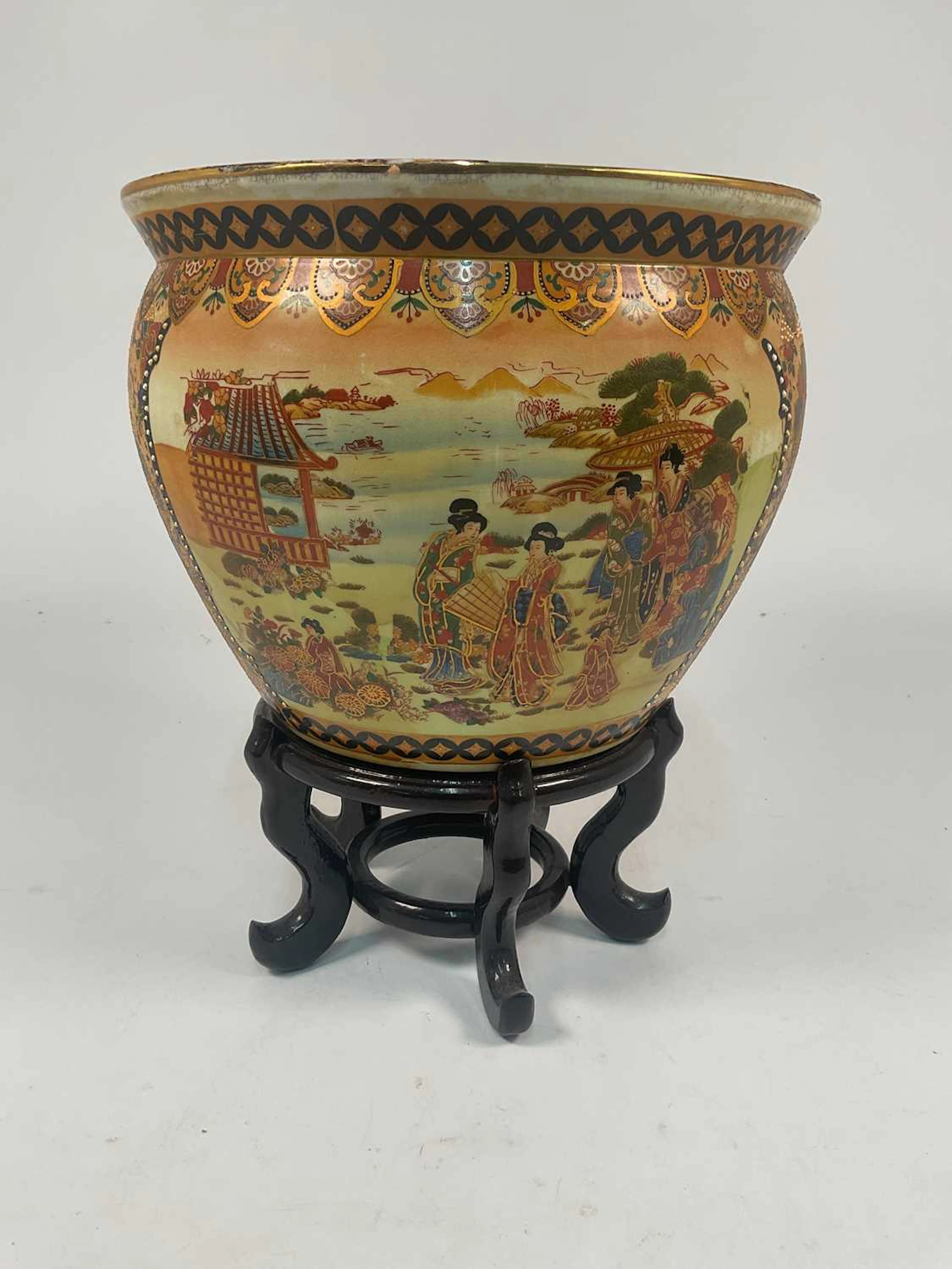A Japanese fish bowl decorated with figures in a landscape setting
