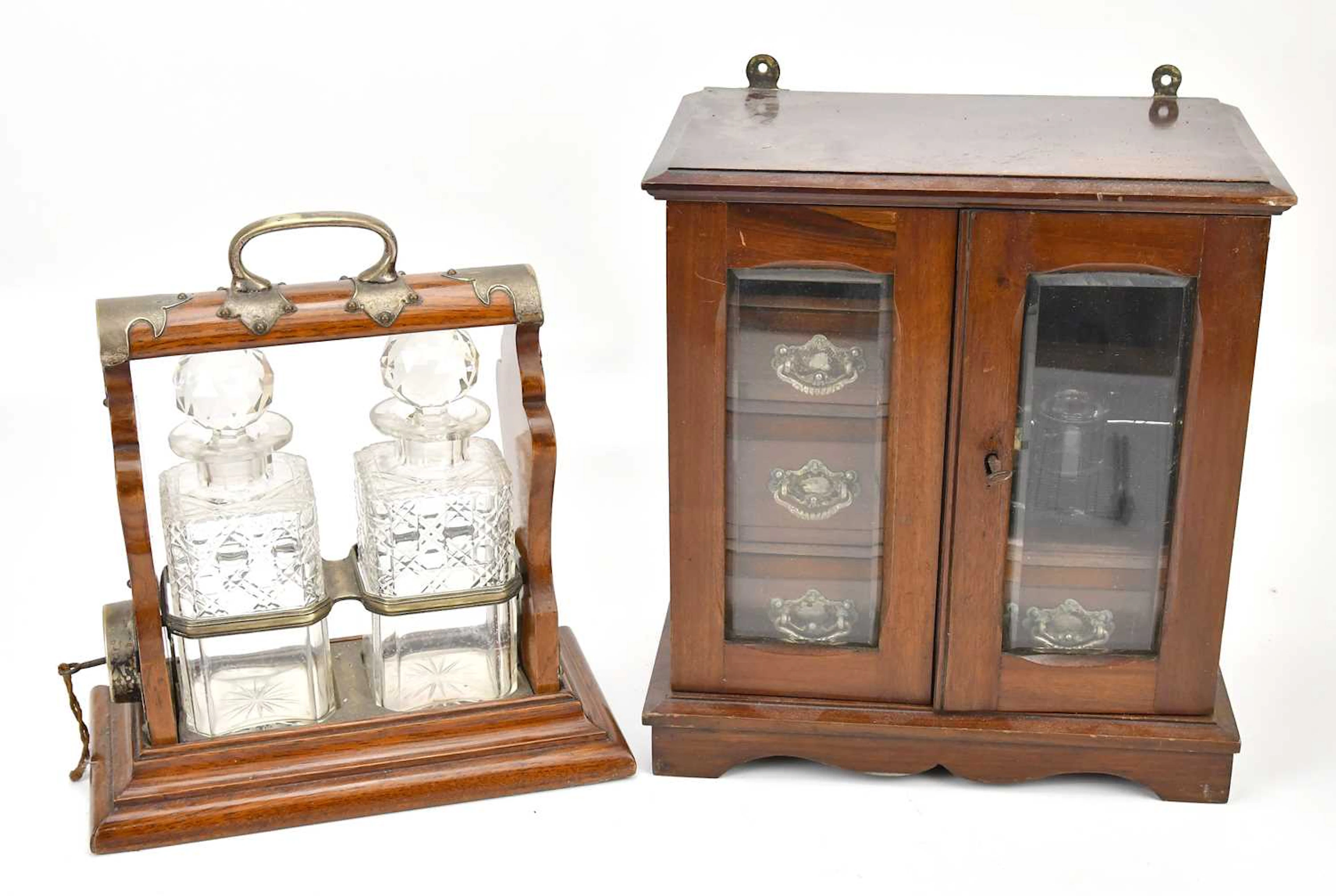 A mahogany smoker's cabinet with two glazed doors and an arrangement of drawers