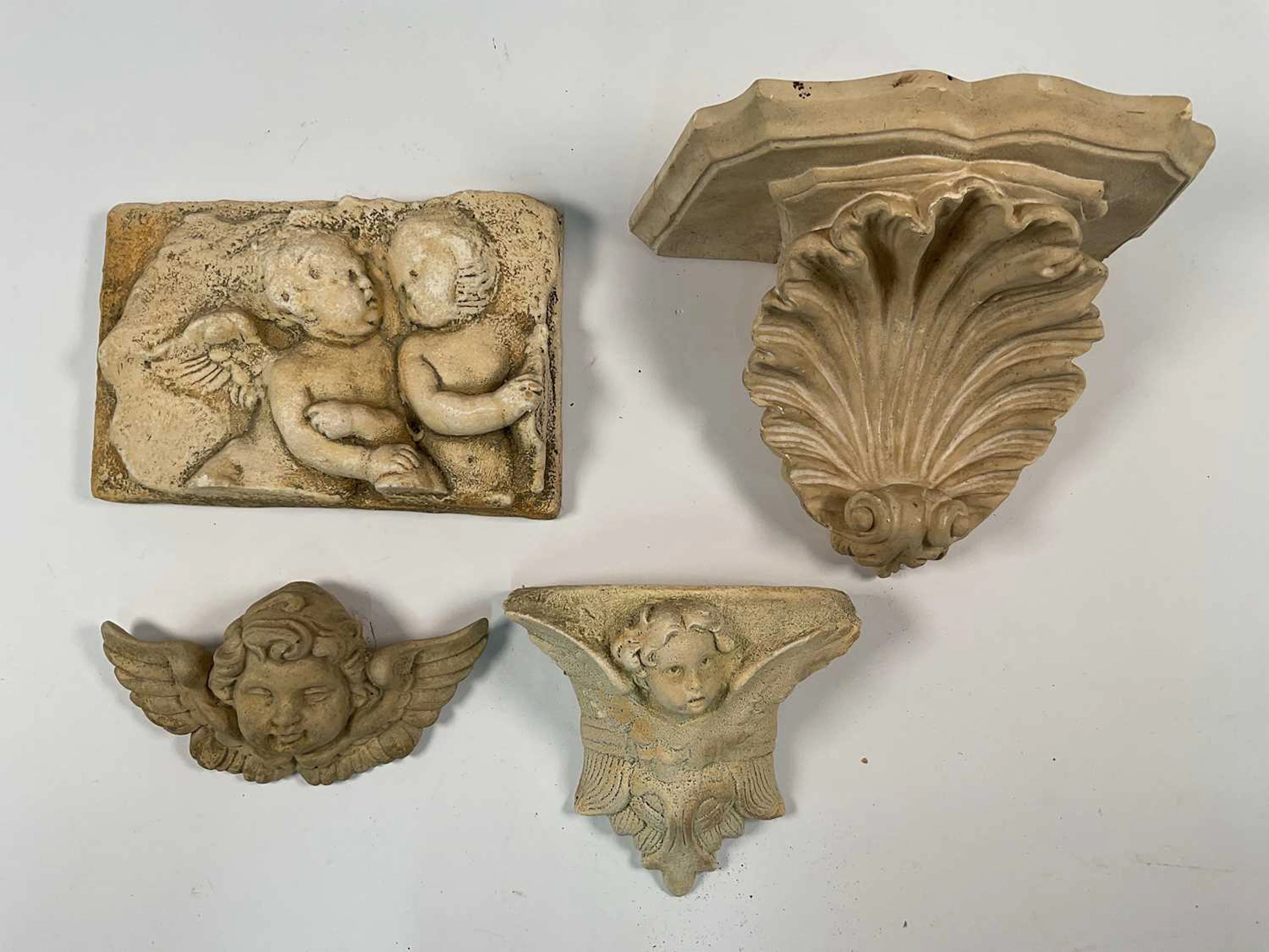A composite stone wall sconce with scalloped shell support