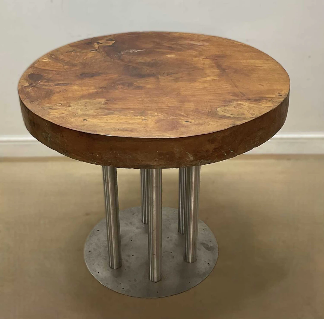 A large elm circular table top raised on a aluminium base