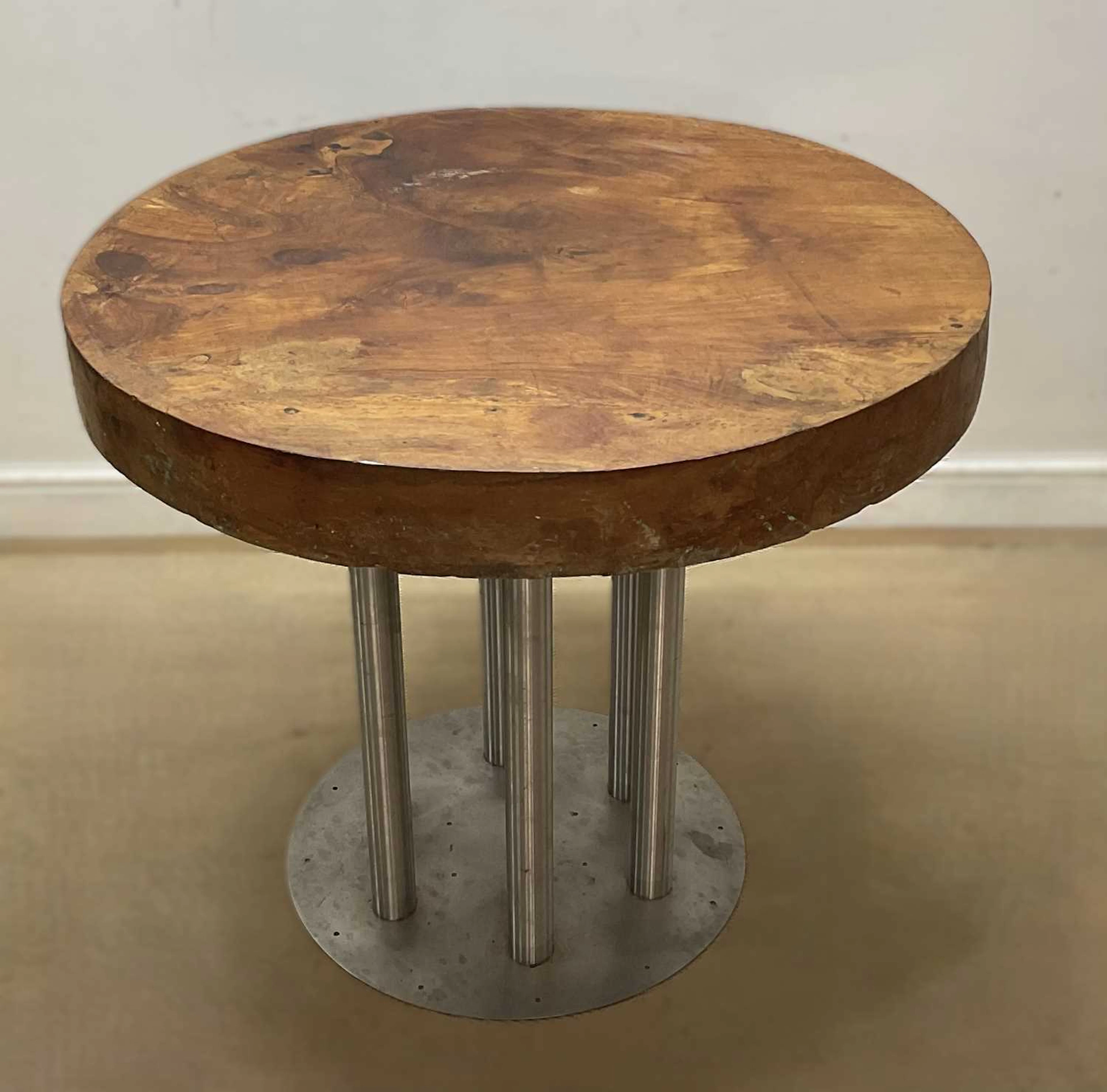 A large elm circular table top raised on a aluminium base