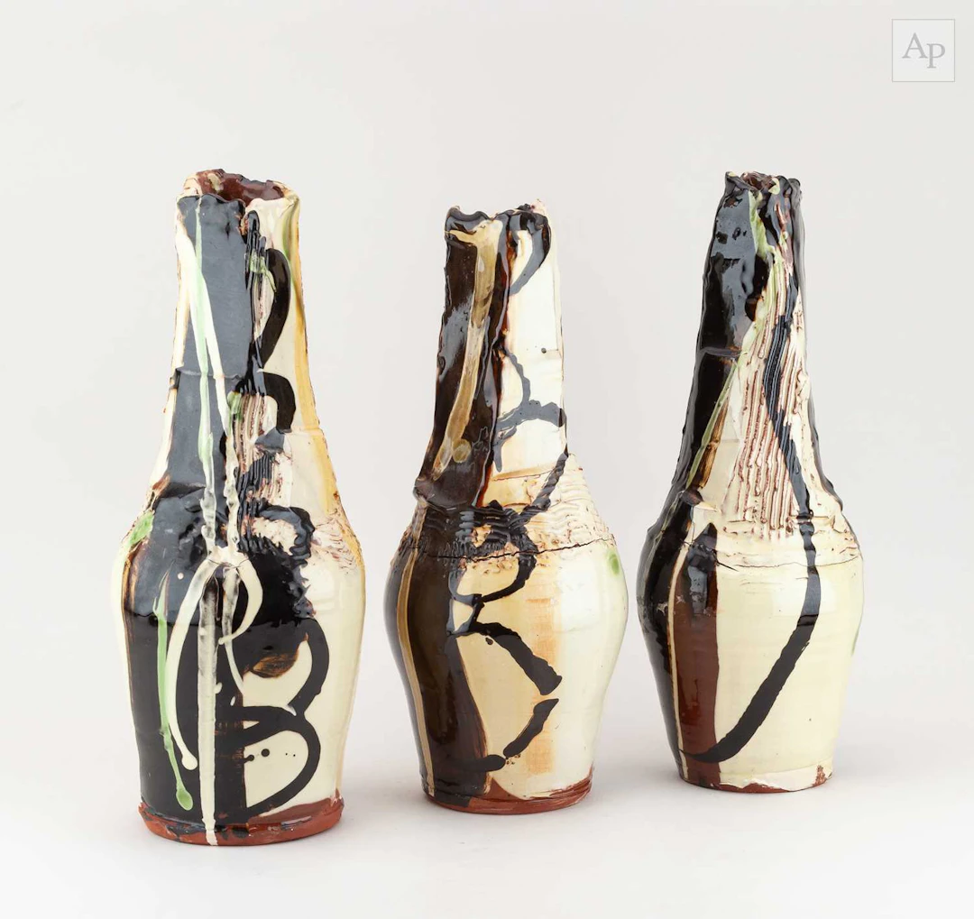 DYLAN BOWEN (born 1967); a trio of tall of slip decorated earthenware bottles
