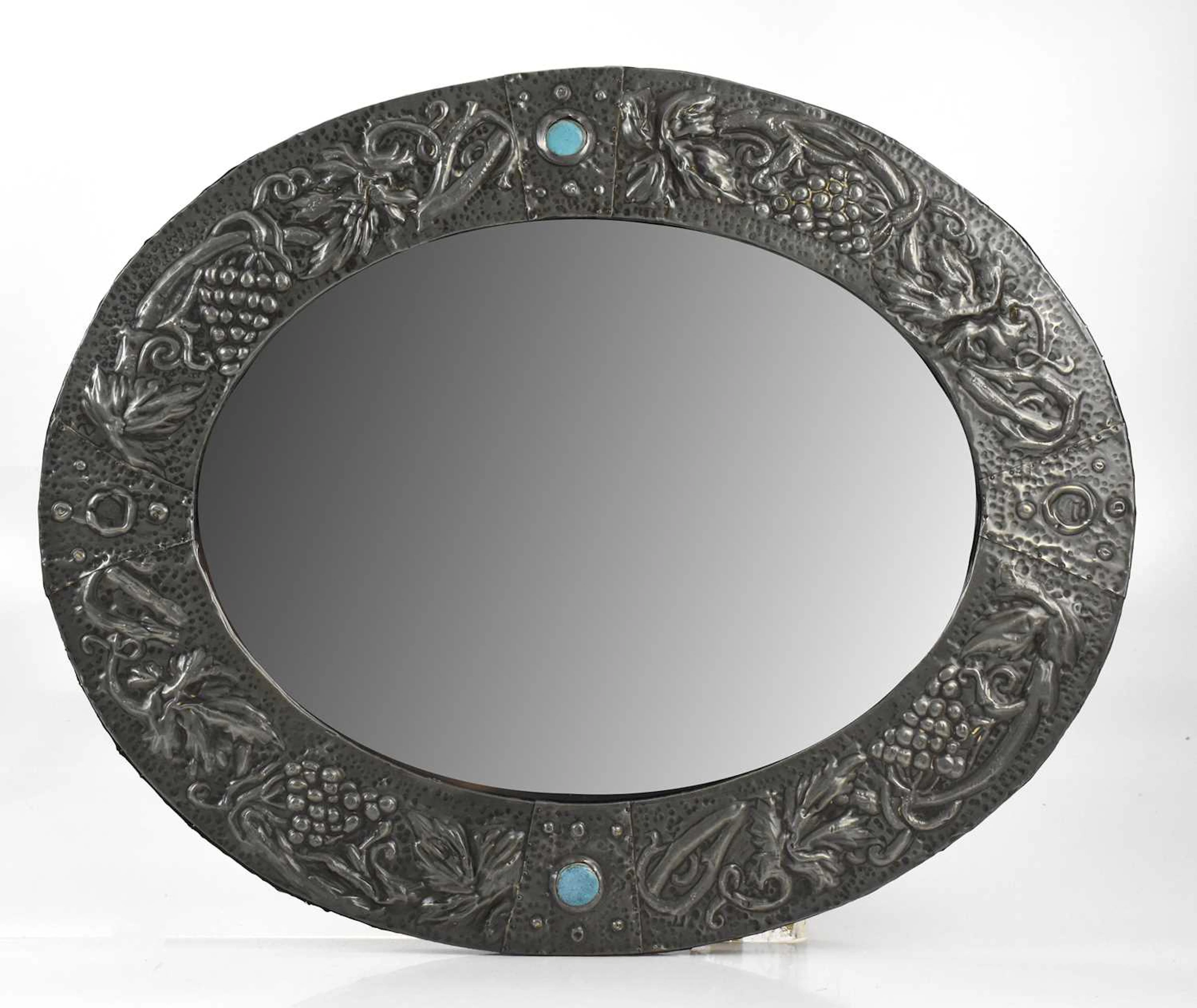 An Arts and Crafts sheet pewter mirror of oval form