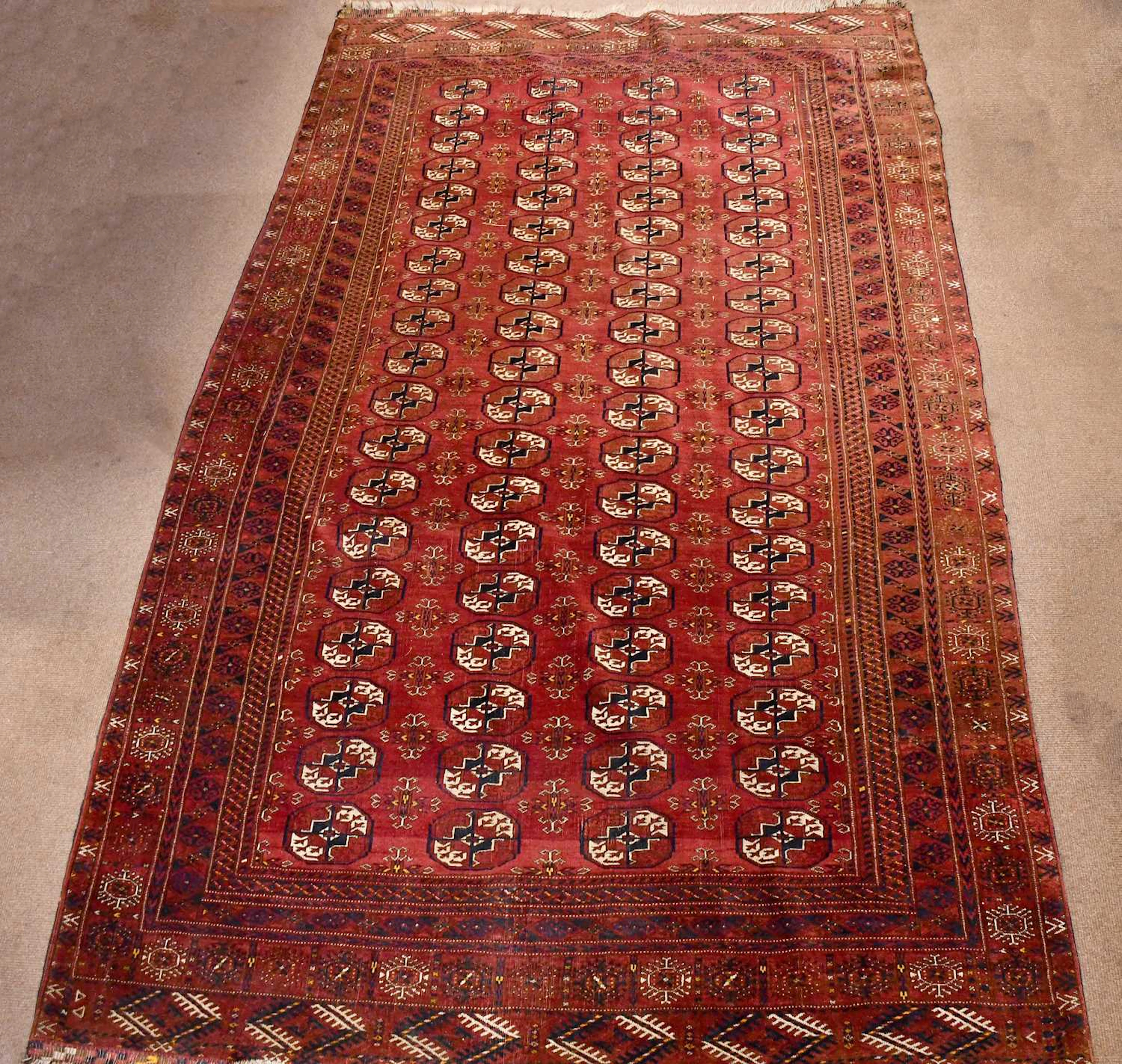 A red ground hand knotted woollen Bokhara style rug