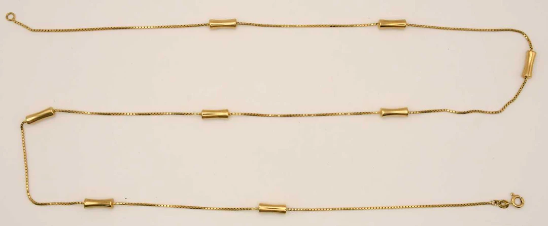 A 9ct yellow gold necklace with eight pillow links between small box chain