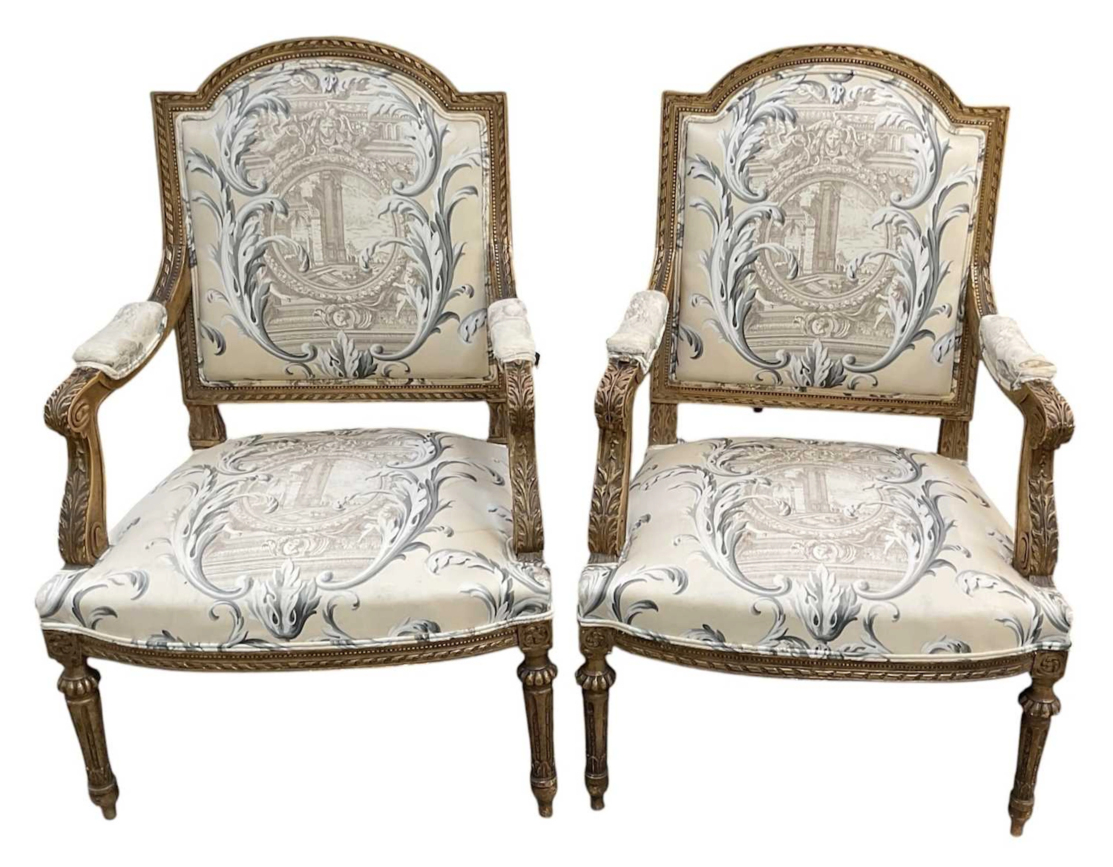 A pair of reproduction French Empire style carved giltwood open arm elbow chairs
