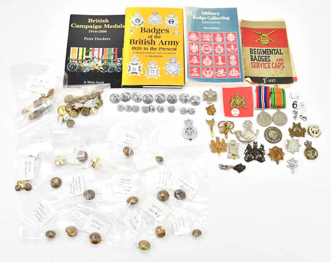 A collection of military cap badges and buttons